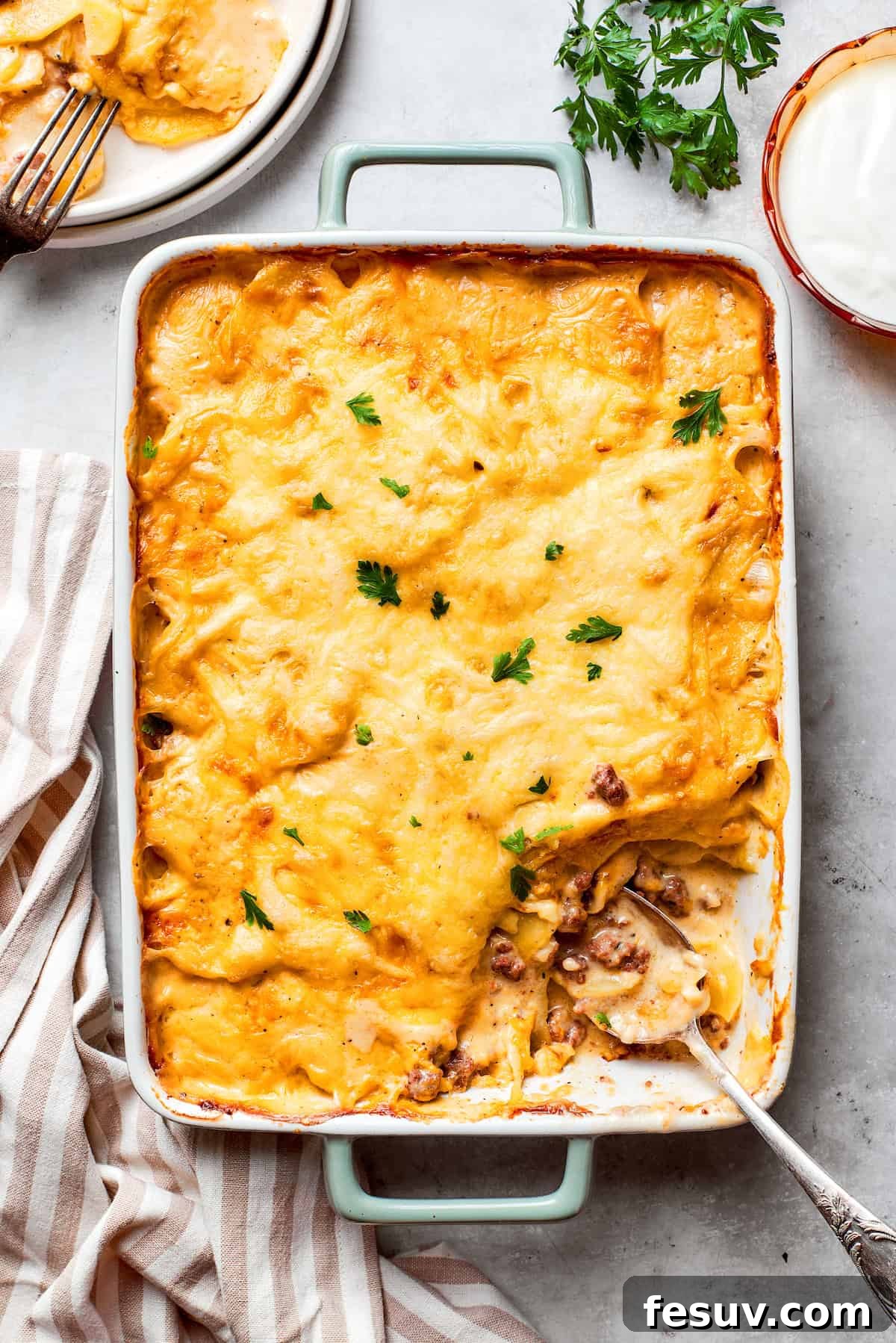 Hearty Beef & Potato Bake 9 A large, beautifully assembled pan of Hamburger Potato Casserole, topped with a generous layer of shredded cheese, is ready to be baked to golden perfection.