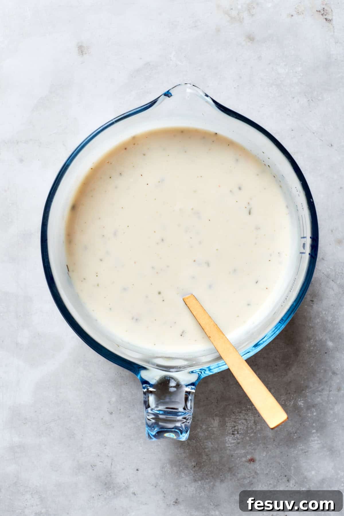 Hearty Beef & Potato Bake 3 The creamy soup mixture, including mushroom soup, milk, sour cream, and Italian seasoning, is thoroughly combined in a mixing bowl until smooth and homogenous.