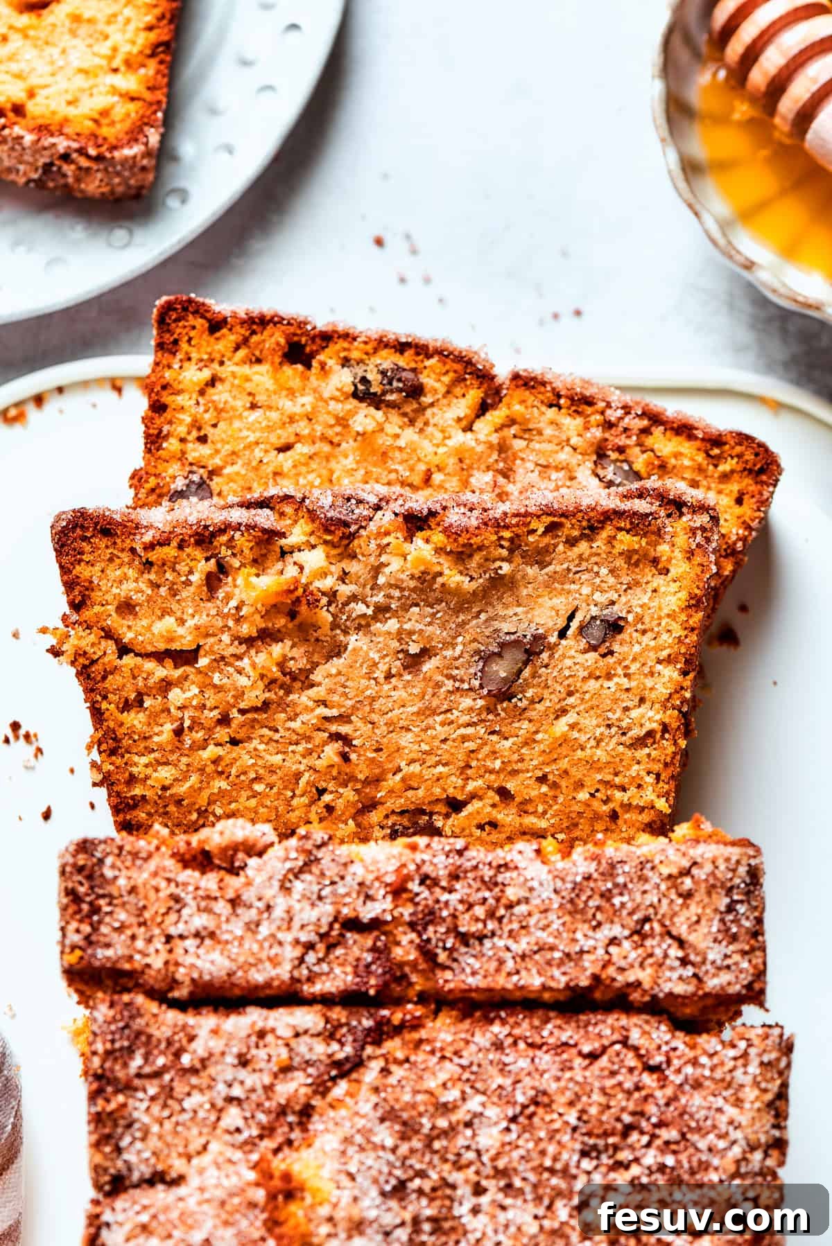 Thick slices of golden brown Amish friendship bread are neatly arranged on a white plate.