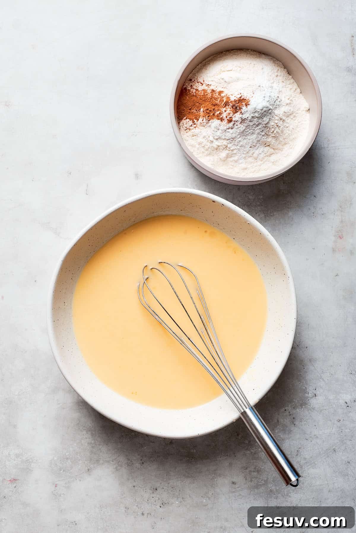 The eggs are whisked into the wet batter until smoothly incorporated and light yellow.