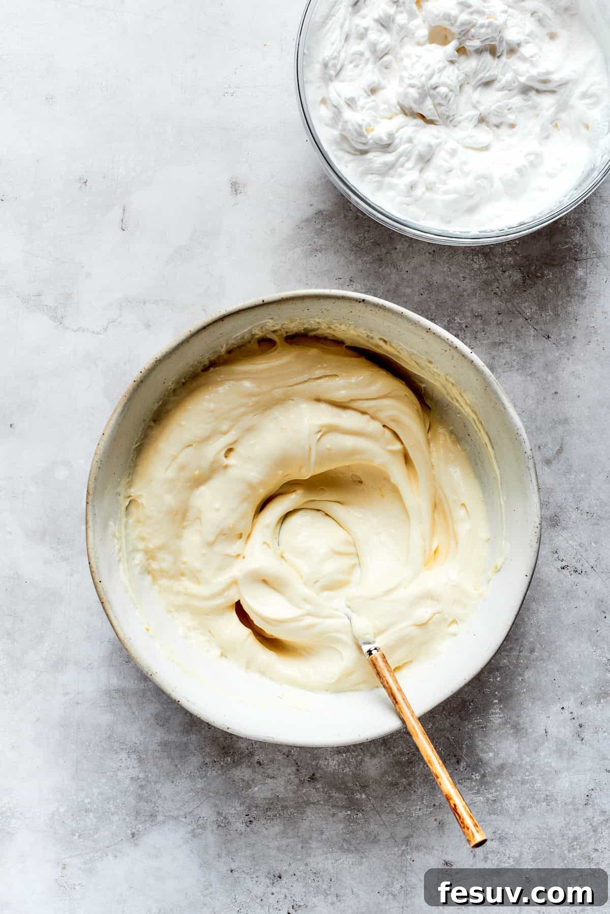Sun-Kissed Lemon Tiramisu 12 Mascarpone cheese, sugar, vanilla, and lemon zest being vigorously mixed in a bowl to create the creamy base for the tiramisu filling.