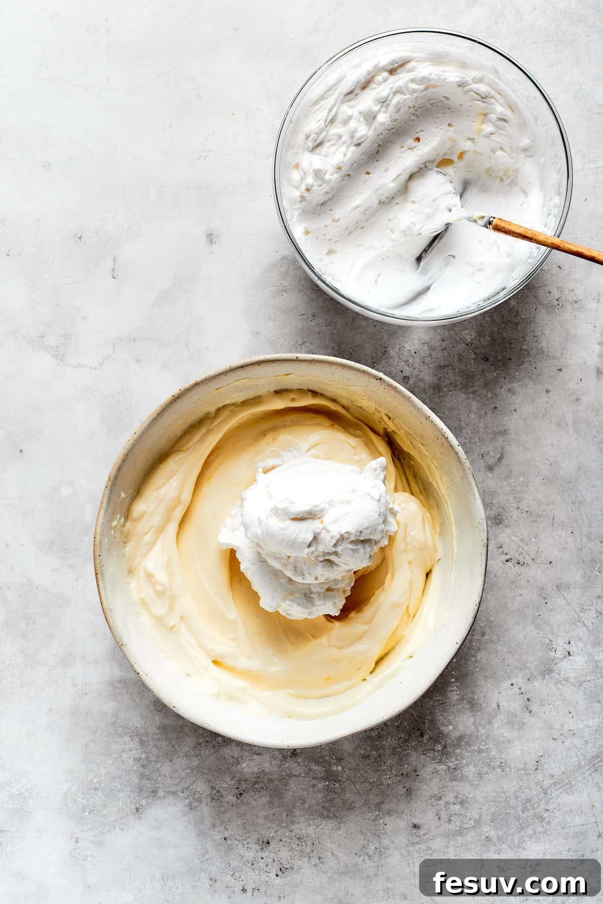 Sun-Kissed Lemon Tiramisu 13 Light and fluffy whipped cream being gently folded into the smooth mascarpone mixture, creating the tiramisu's signature creamy texture.