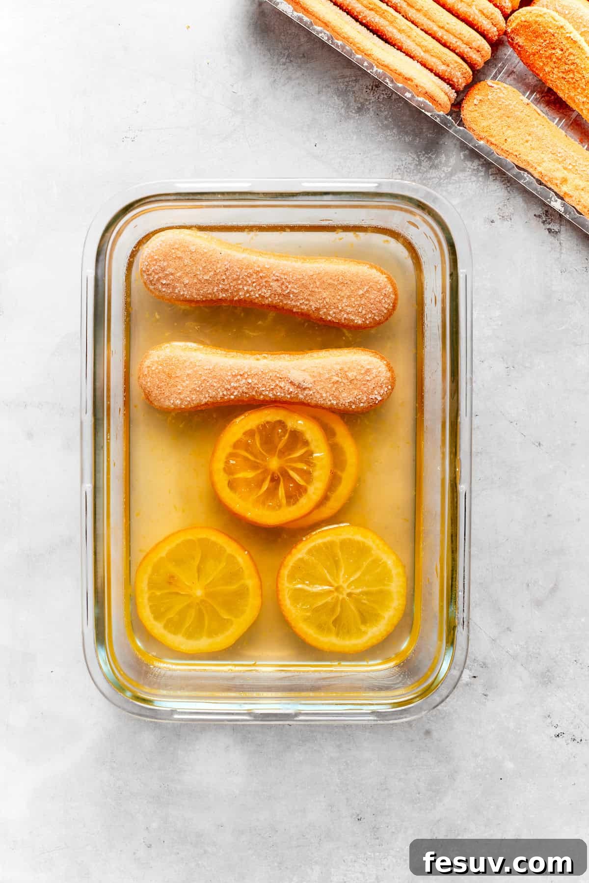 Sun-Kissed Lemon Tiramisu 14 Ladyfinger cookies, lightly dipped in lemon syrup, carefully arranged in the bottom of a baking dish.