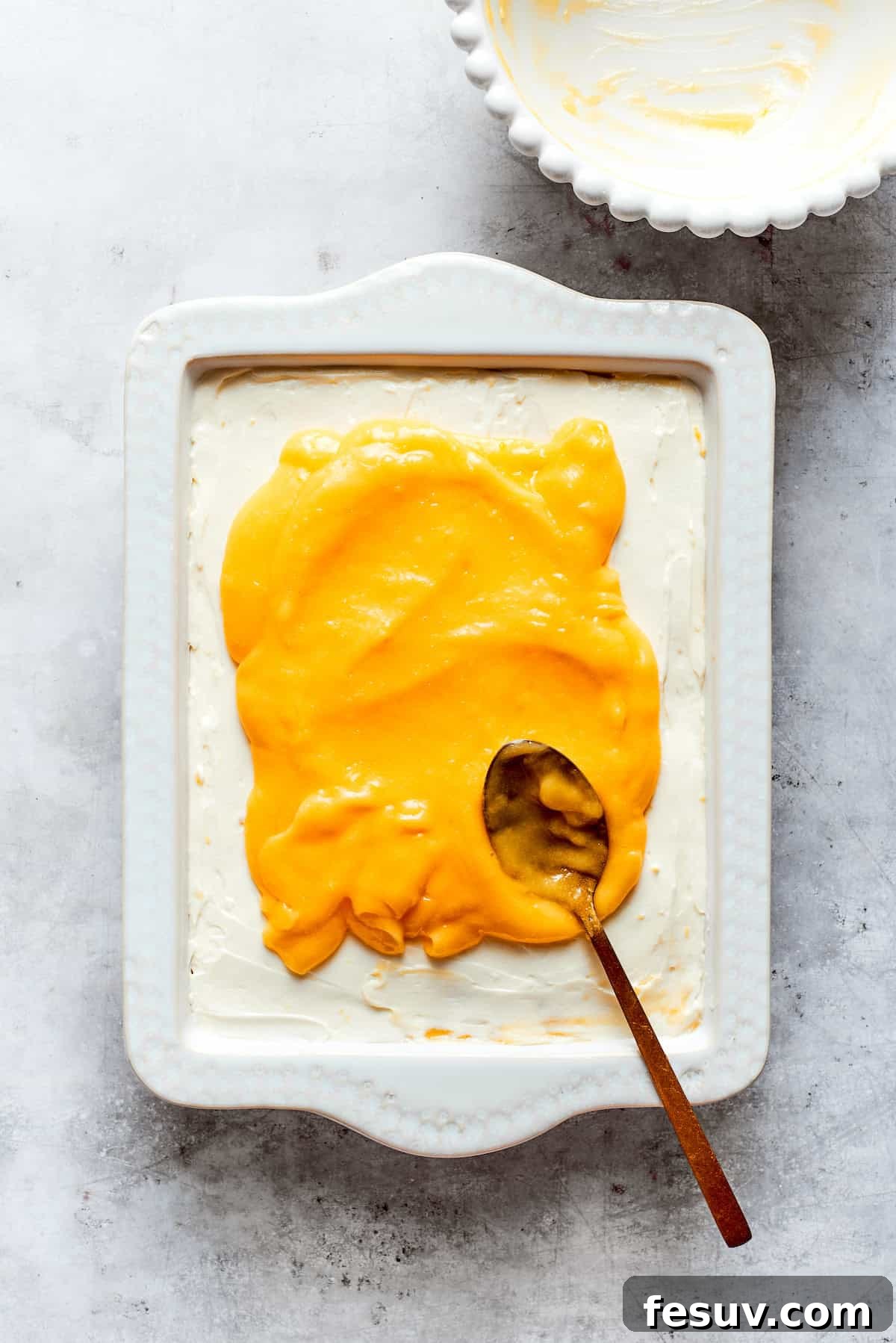 Sun-Kissed Lemon Tiramisu 18 The final layer of smooth, bright lemon curd being spread evenly over the top of the assembled lemon tiramisu.