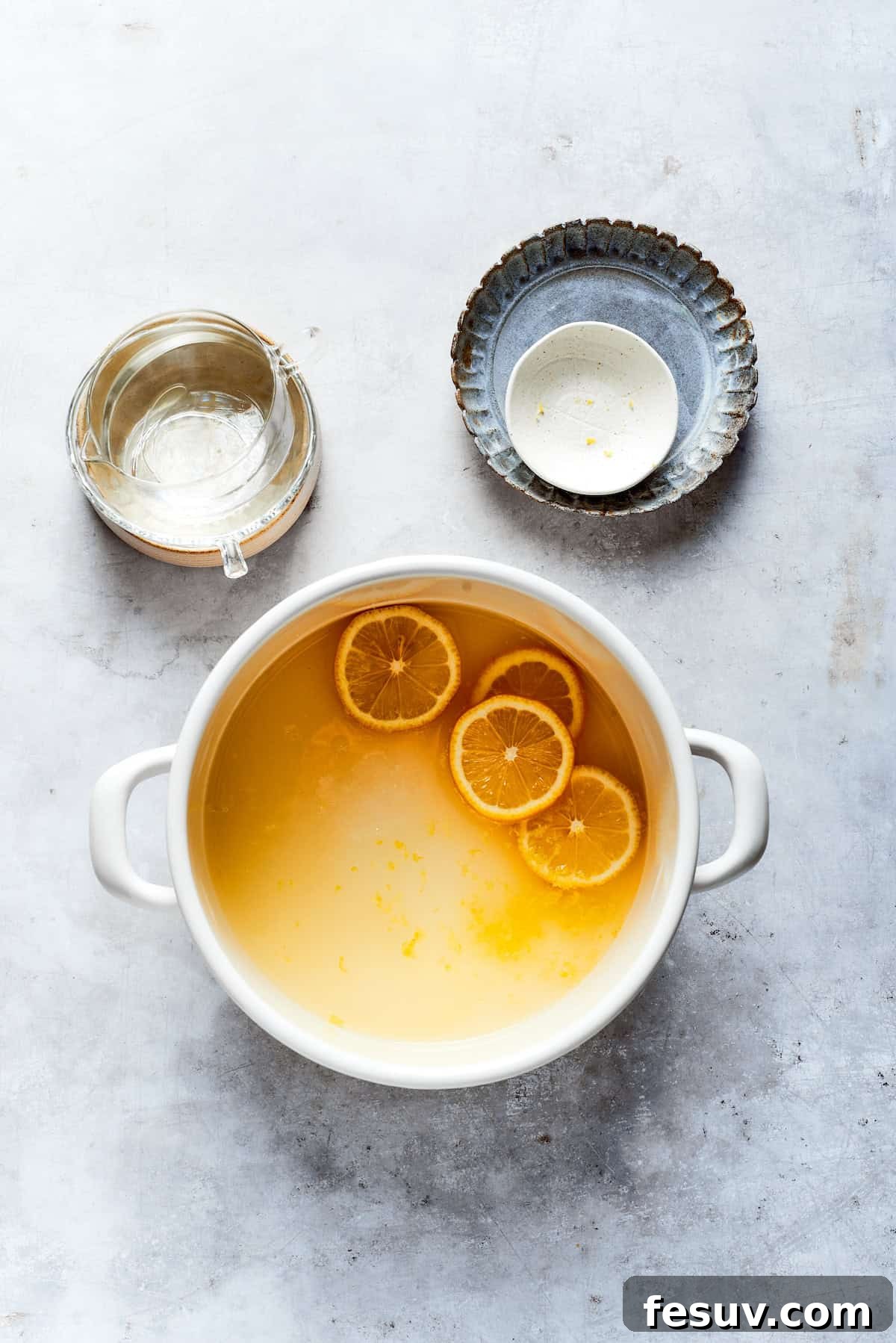 Sun-Kissed Lemon Tiramisu 8 Lemon juice, water, sugar, and zest simmering in a pot on the stove to create the lemon syrup.