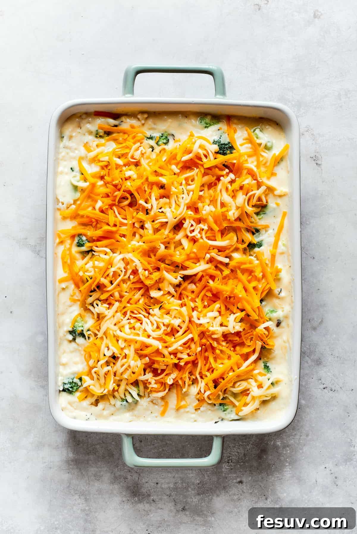 From-scratch Broccoli & Rice Casserole folds tender broccoli and fluffy white rice into a gorgeously creamy three-cheese sauce. Shredded cheese tops broccoli & rice casserole.