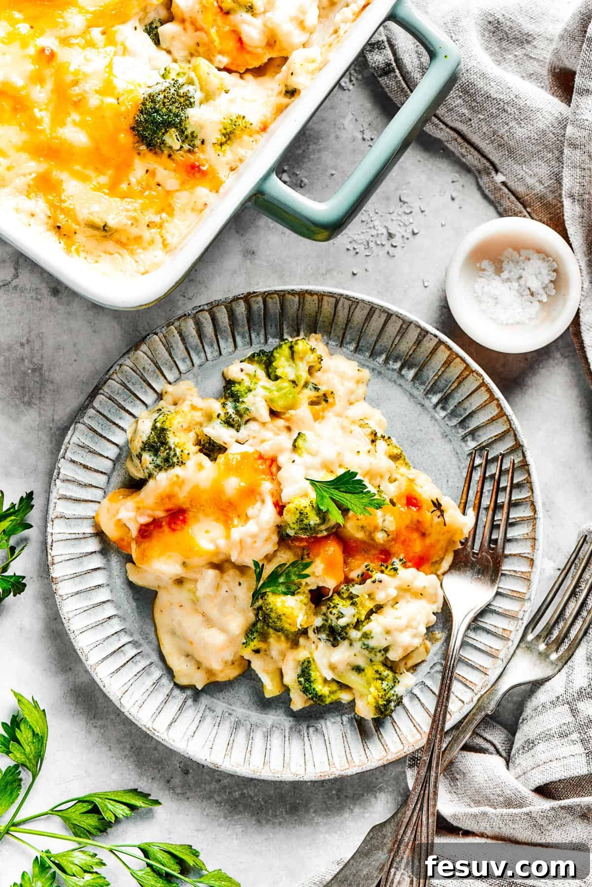From-scratch Broccoli & Rice Casserole folds tender broccoli and fluffy white rice into a gorgeously creamy three-cheese sauce. A serving of broccoli rice casserole served on a dinner plate.