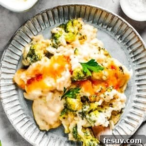 Creamy Broccoli Rice Bake 2 A serving of broccoli & rice casserole on a blue plate with a fork.