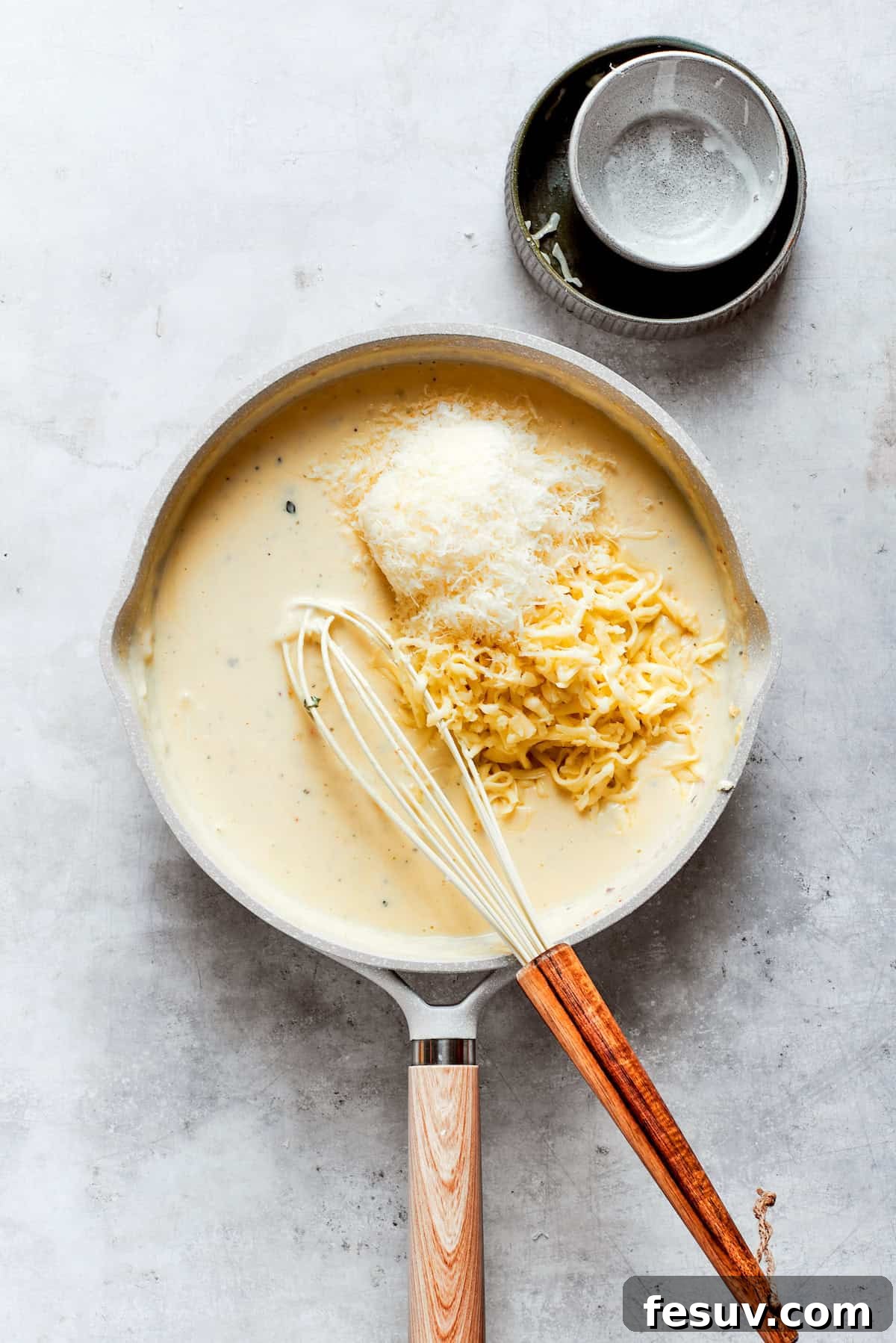 From-scratch Broccoli & Rice Casserole folds tender broccoli and fluffy white rice into a gorgeously creamy three-cheese sauce. Cheeses are added to a roux in a pot.