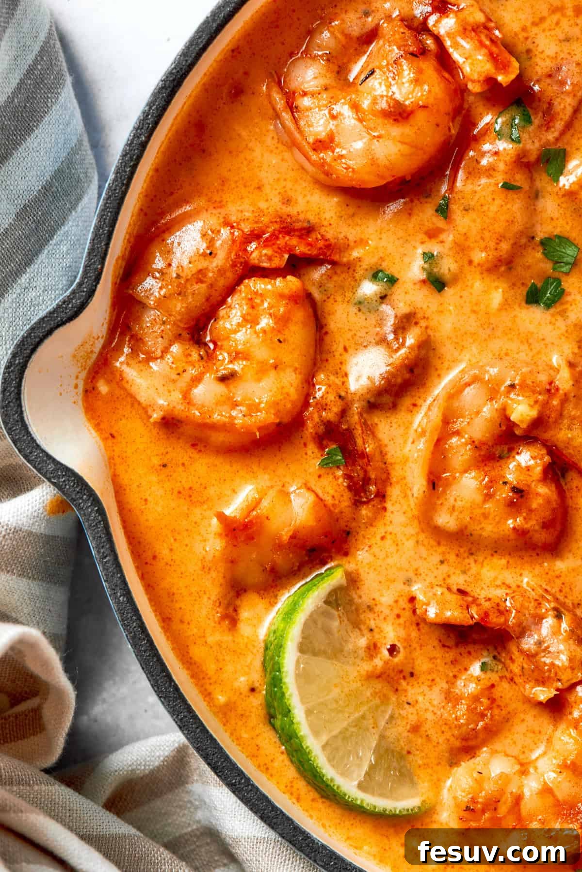 Close-up shot of Cajun shrimp in a skillet, showcasing the rich sauce and tender shrimp.