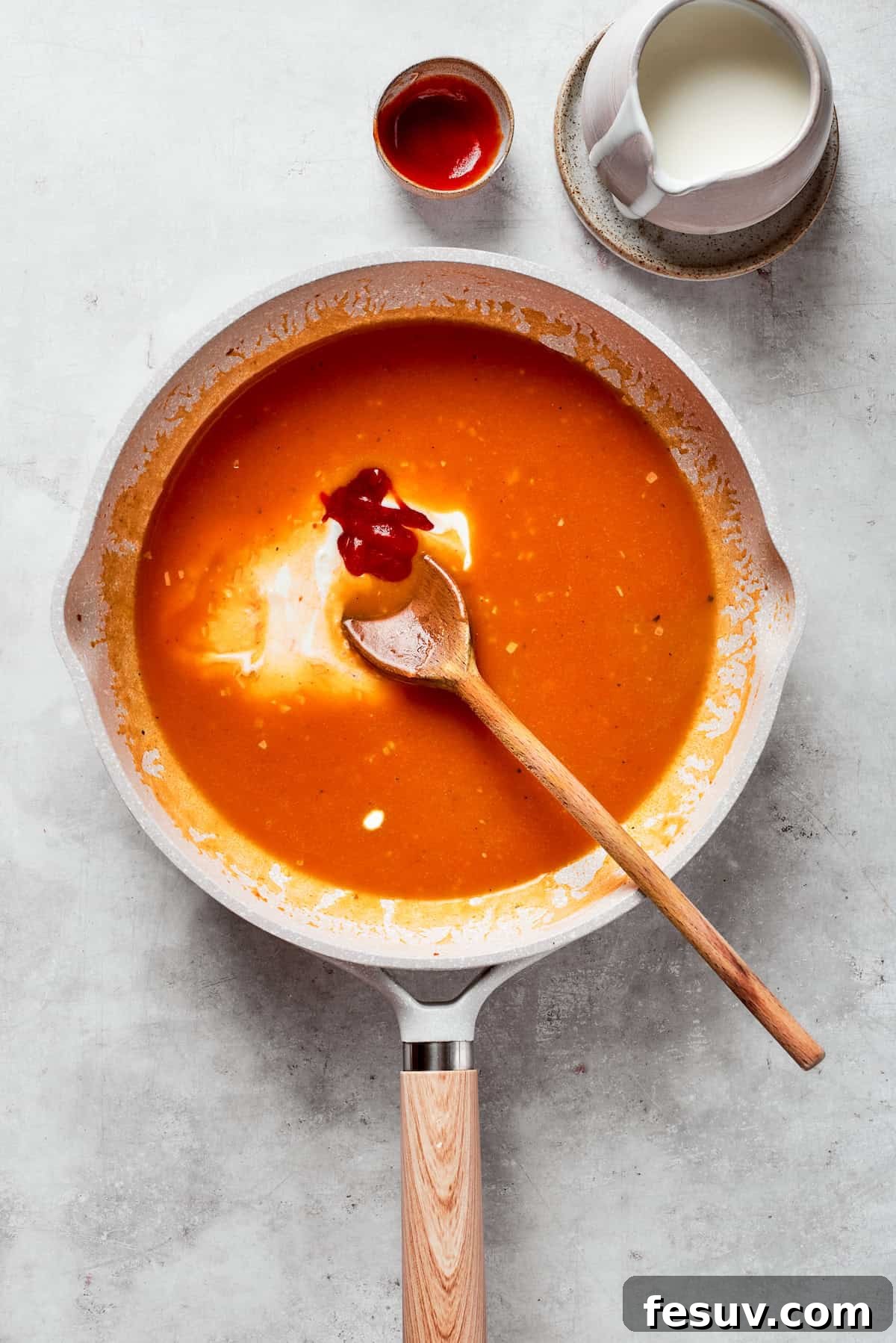 Cream is stirred into a tomato sauce.