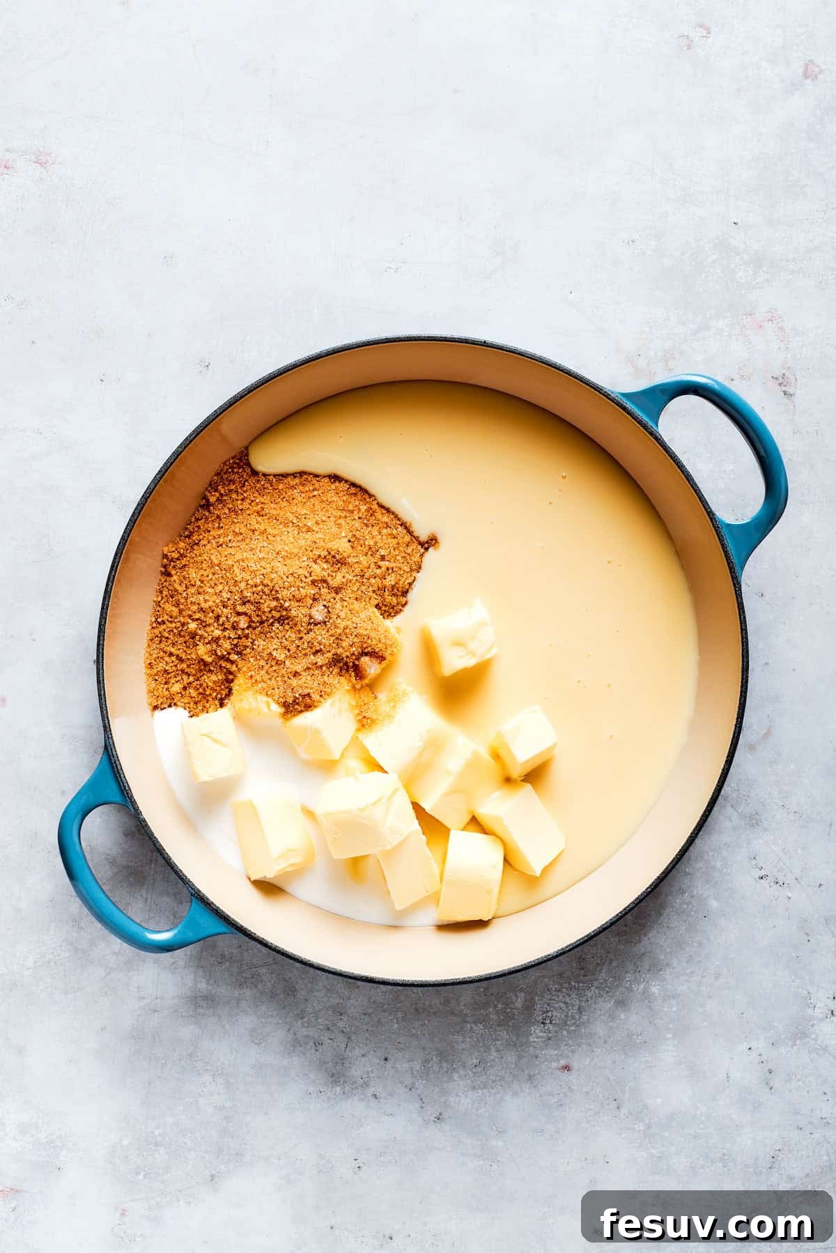 Butter, brown sugar, condensed milk, vanilla, and cream are combined in a pot for the caramel.