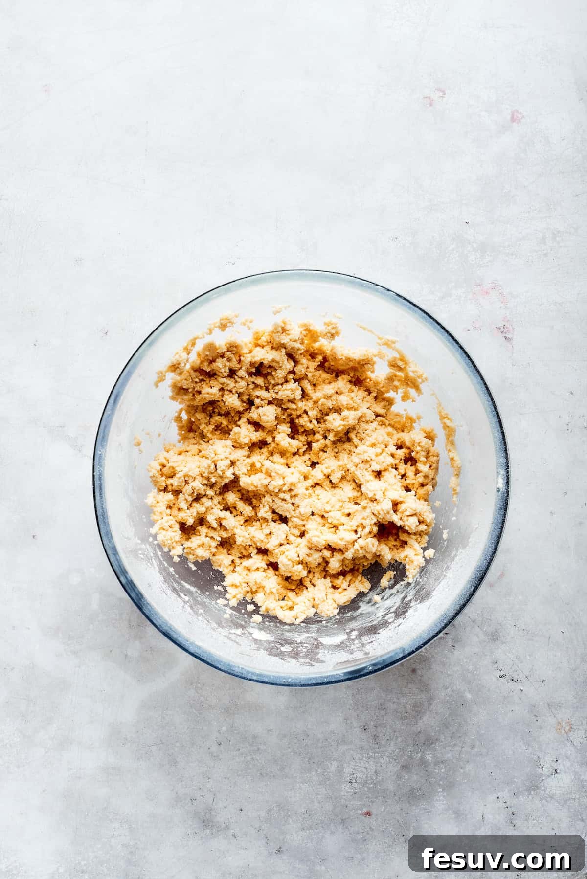 Shortbread dough in a bowl, ready to be pressed into a pan.