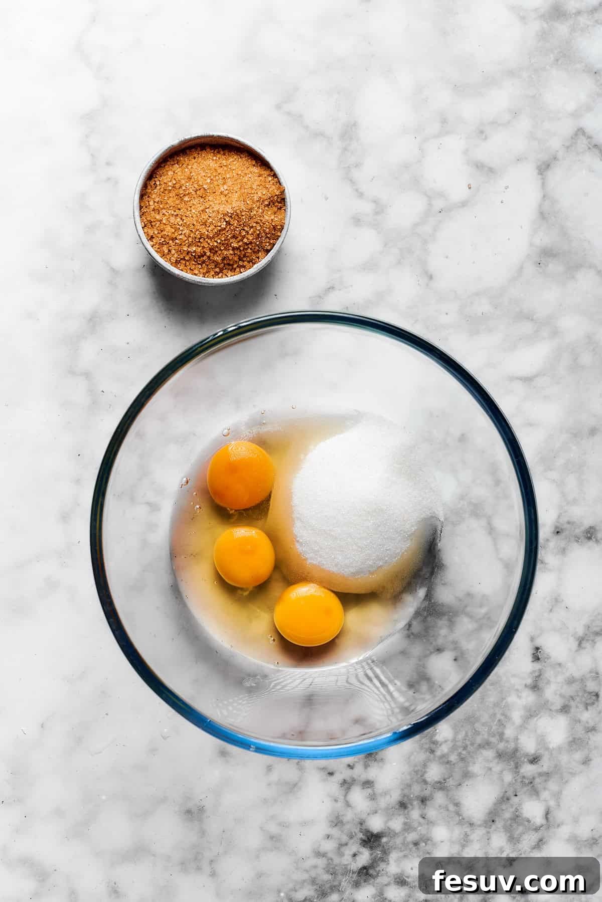 Eggs, sugar, and oil are combined in a bowl.