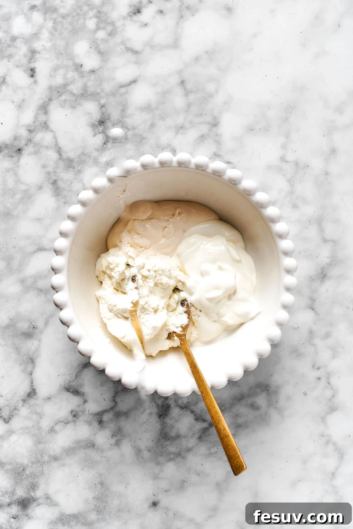 Preparing the Creamy Cheese Mixture Ricotta, cream cheese, and sour cream in a white bowl, ready to be mixed into a creamy cheese blend.