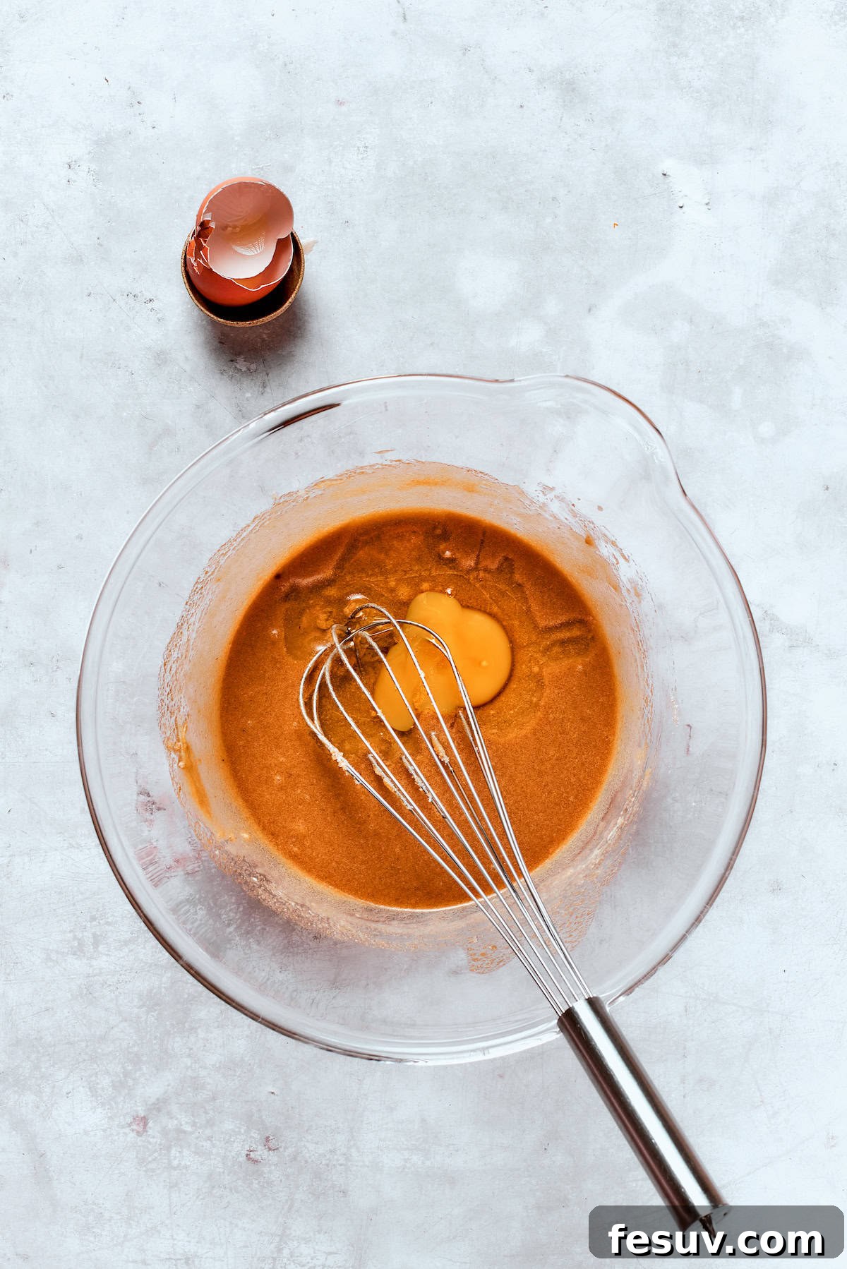 An egg and the cooled, reduced apple cider are whisked into the butter and sugar mixture until well combined.