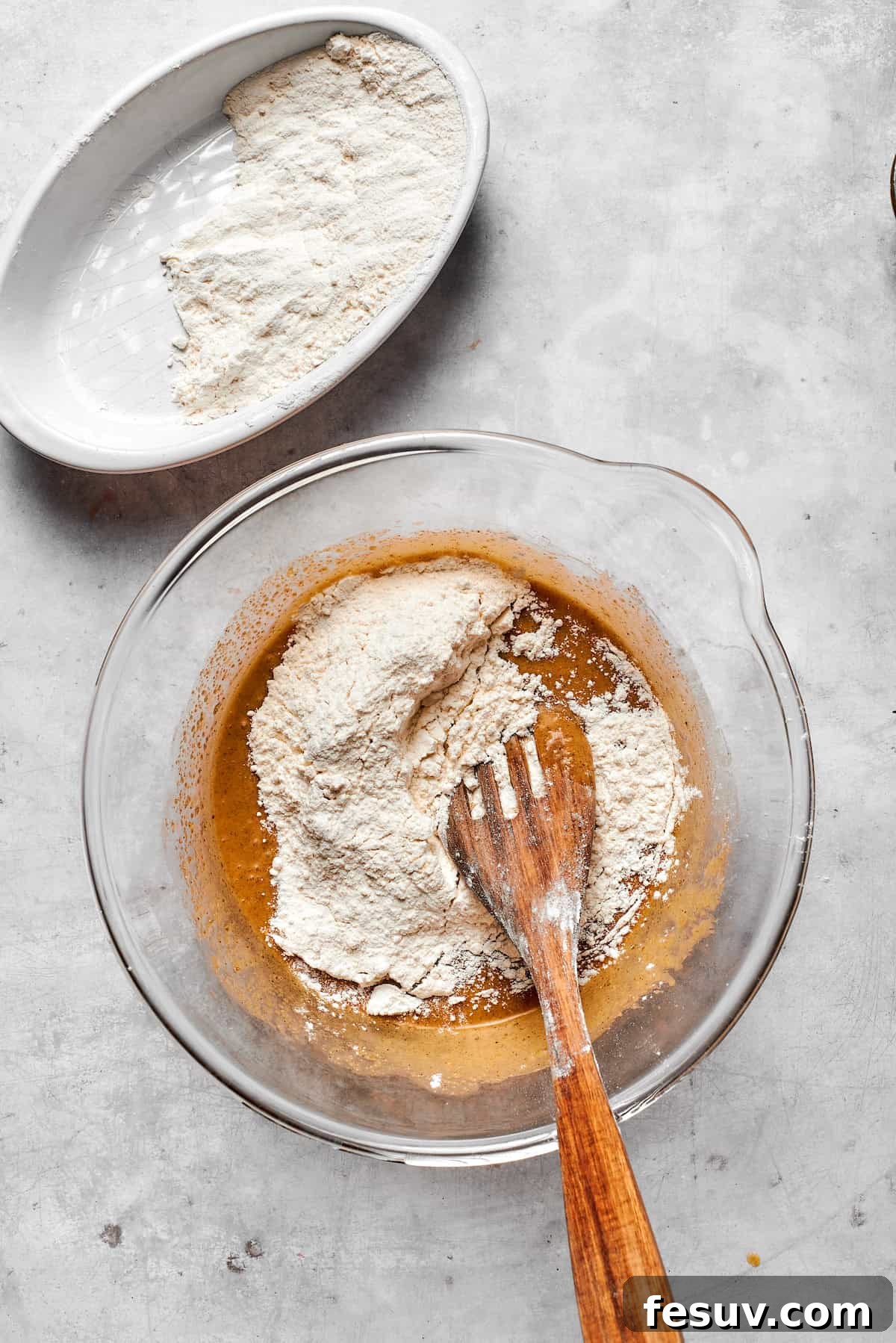 The dry ingredient mixture being gently folded into the wet cookie dough base.