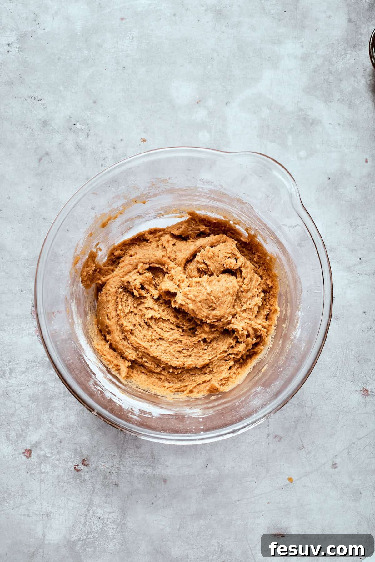 A bowl of well-mixed cookie dough, smooth and ready for chocolate chips.