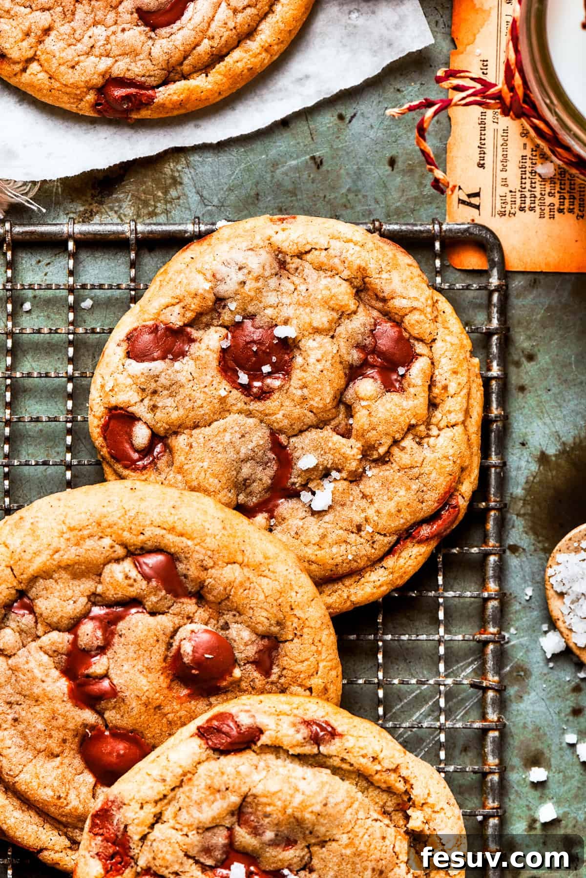 A batch of perfectly baked brown butter chocolate chip cookies cooling on a wire rack.