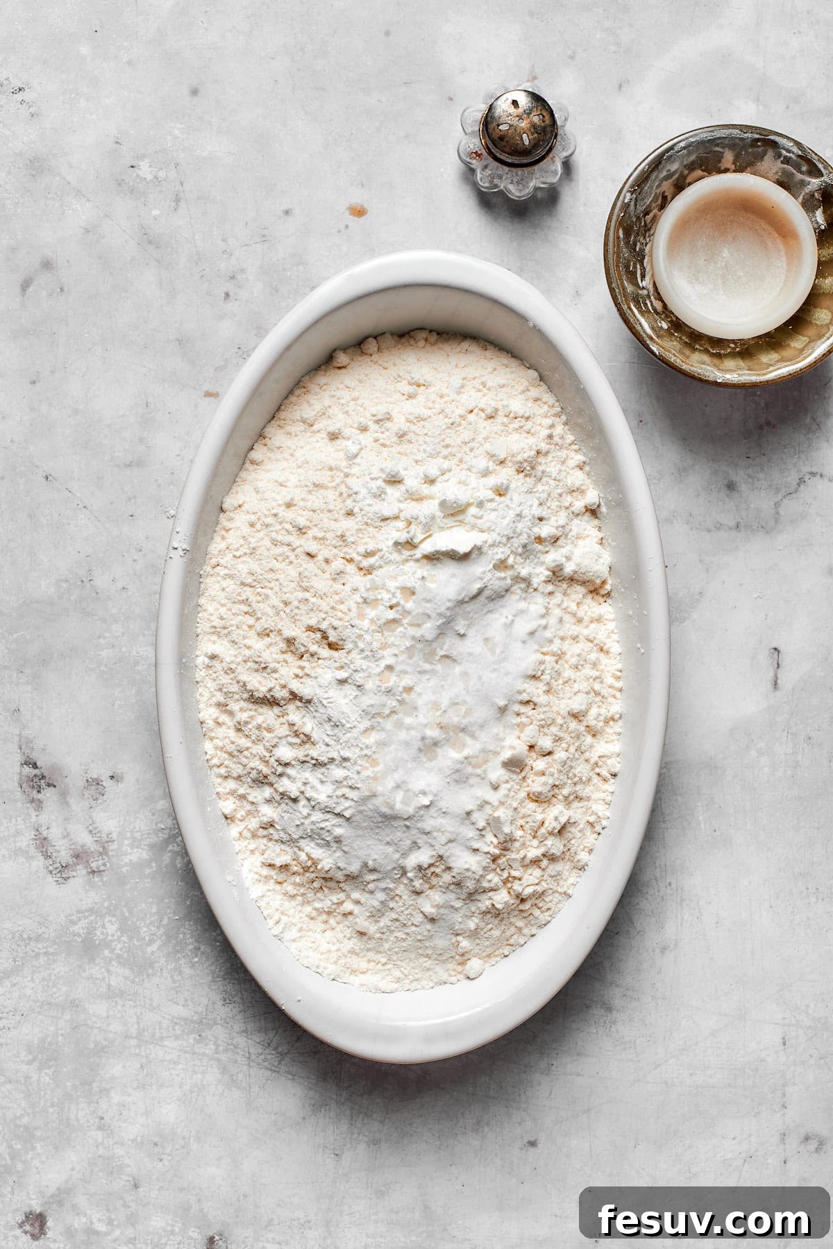A bowl containing all-purpose flour, cornstarch, baking soda, and salt, ready to be whisked.