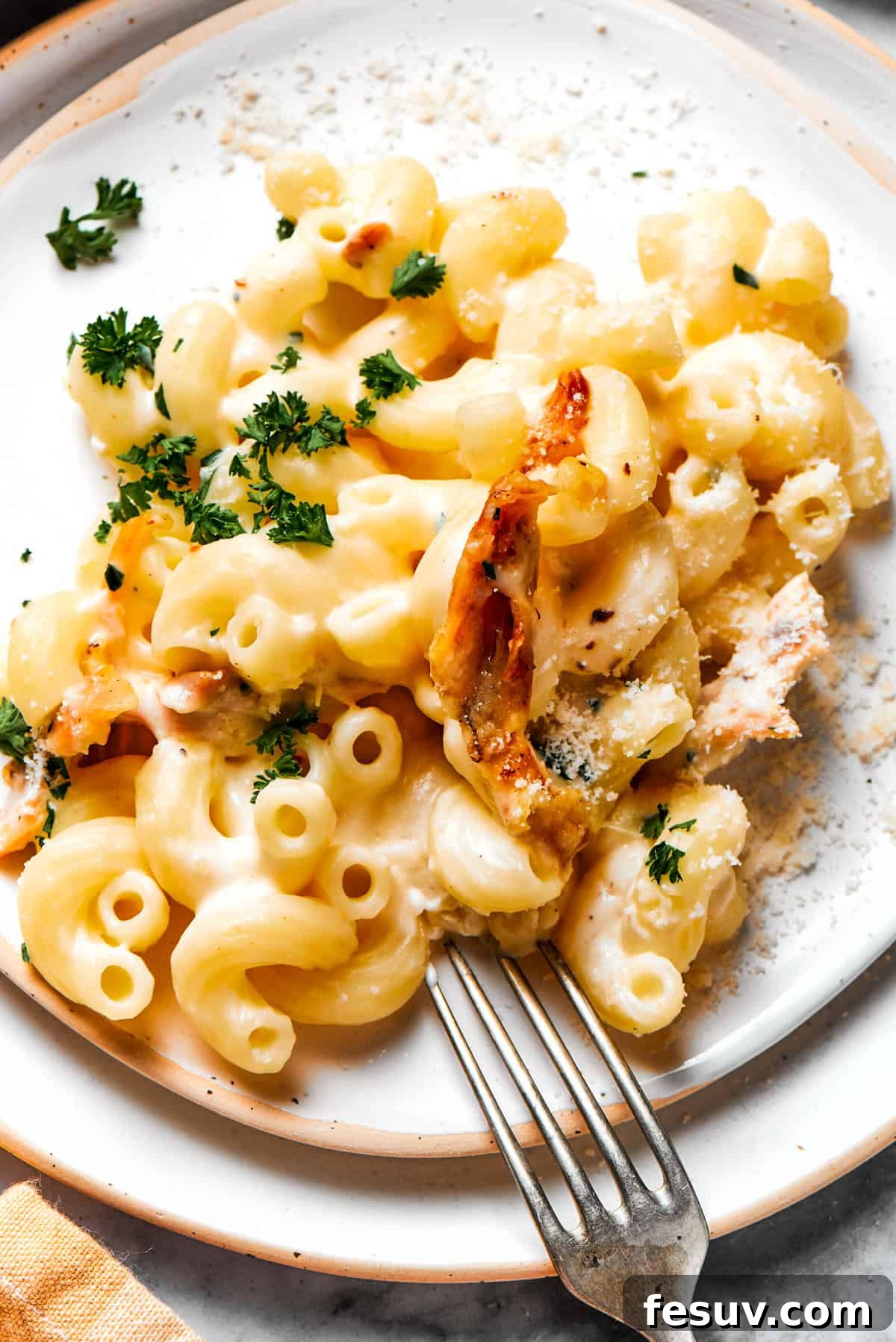 A beautifully plated dish of creamy Garlic Parmesan Chicken Pasta, ready to savor. A perfectly portioned serving of creamy garlic parmesan chicken pasta on a crisp white dinner plate, artfully garnished with fresh chopped parsley.
