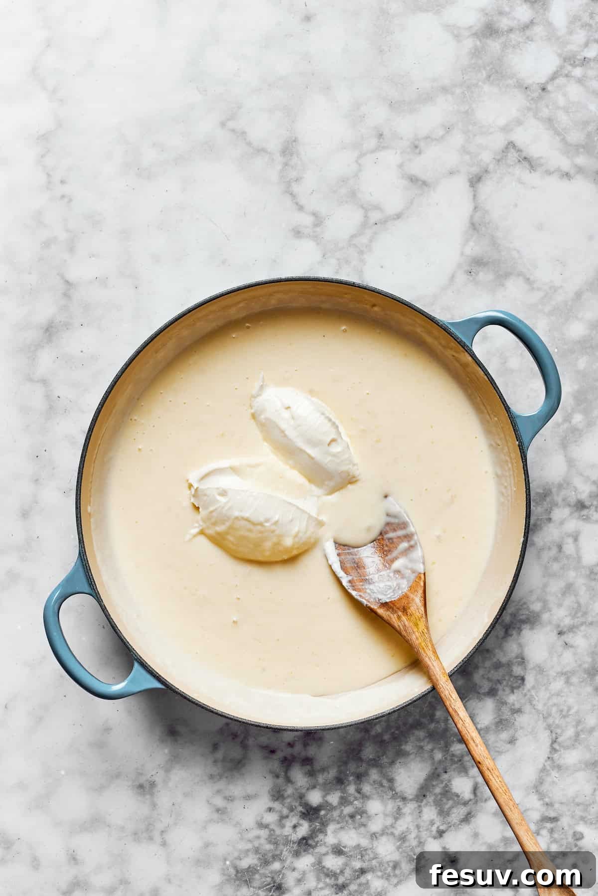 Melt Parmesan and cream cheese into the sauce for the ultimate creaminess. Freshly shredded Parmesan cheese and softened, cubed cream cheese being gently stirred into the smooth, thickened creamy sauce in a large saucepan for ultimate richness.