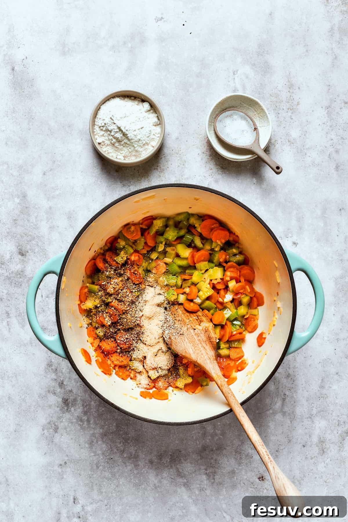 Chicken pot pie casserole is everything you love about the classic comfort food, baked under fluffy buttermilk biscuits instead of pie crust! Carrots, onions, and celery cooking in butter in a large saucepan on a stovetop.