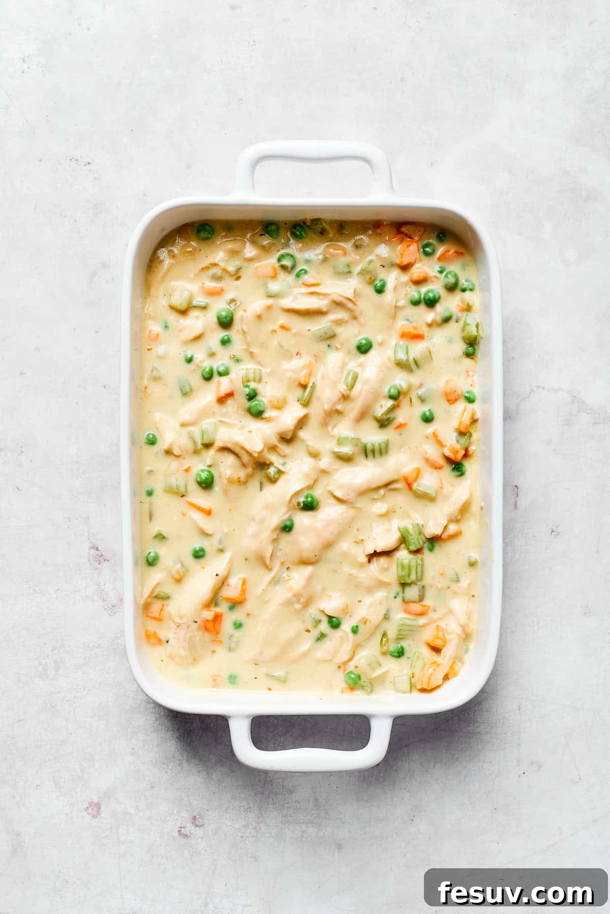Creamy chicken filling spread evenly in a 9x13 inch baking dish.
