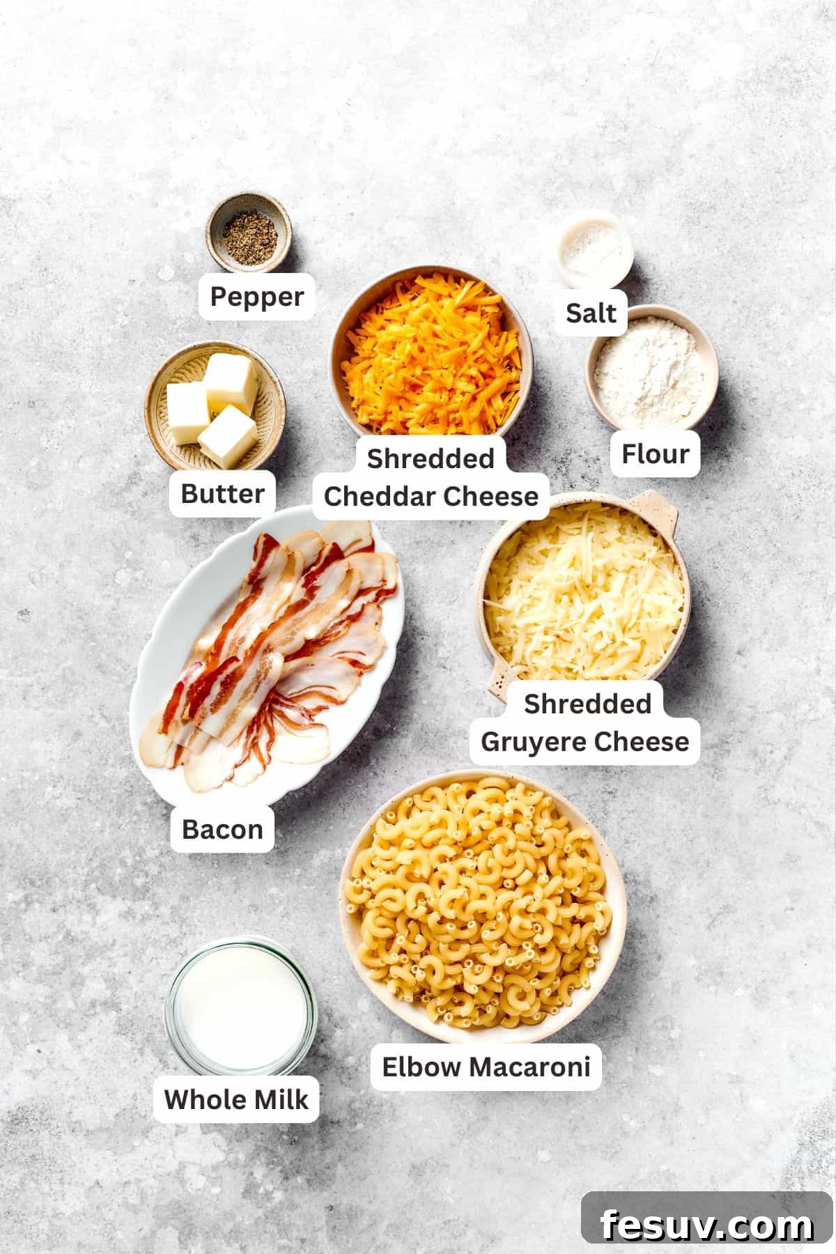 A visually appealing flat lay of all the fresh ingredients required to make the bacon mac and cheese, clearly labeled for easy identification.