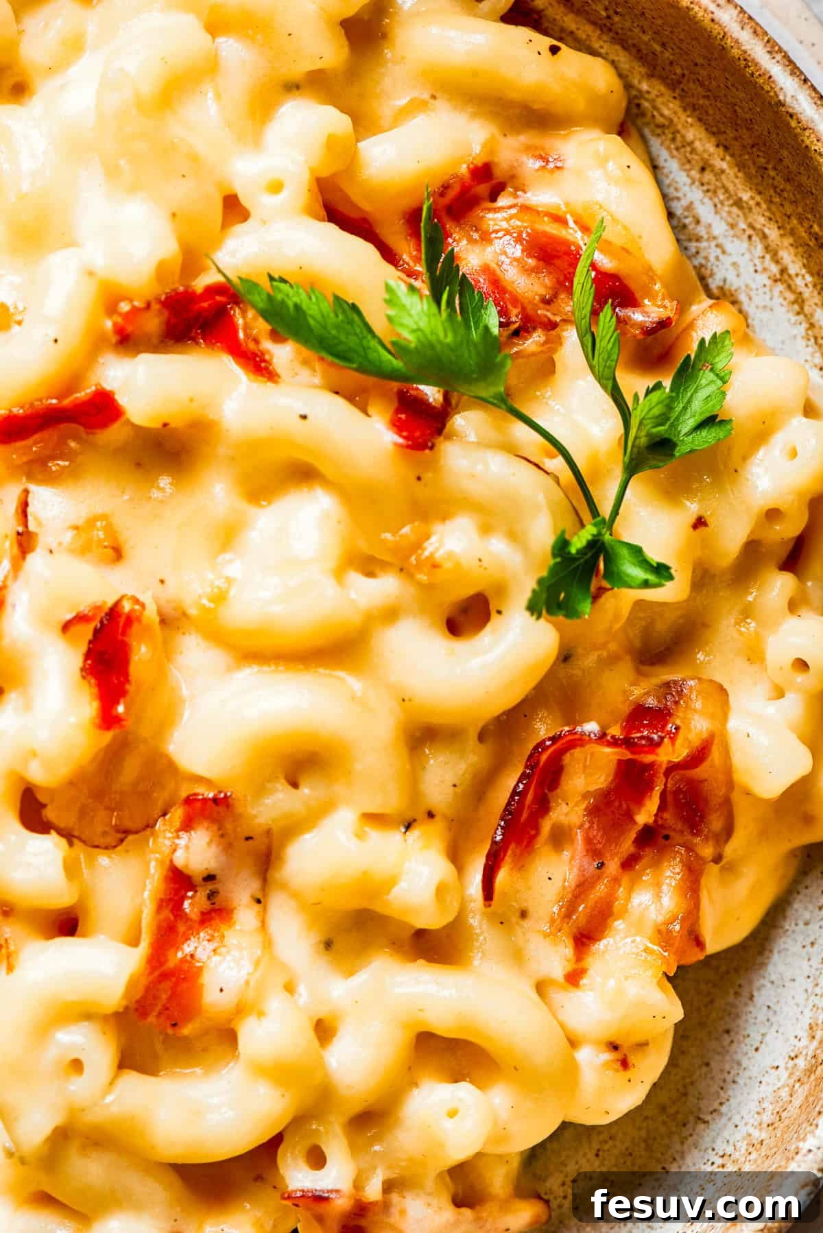 A close-up shot revealing the rich, creamy texture of bacon mac and cheese, with perfectly melted cheese and crisp bacon pieces visible.