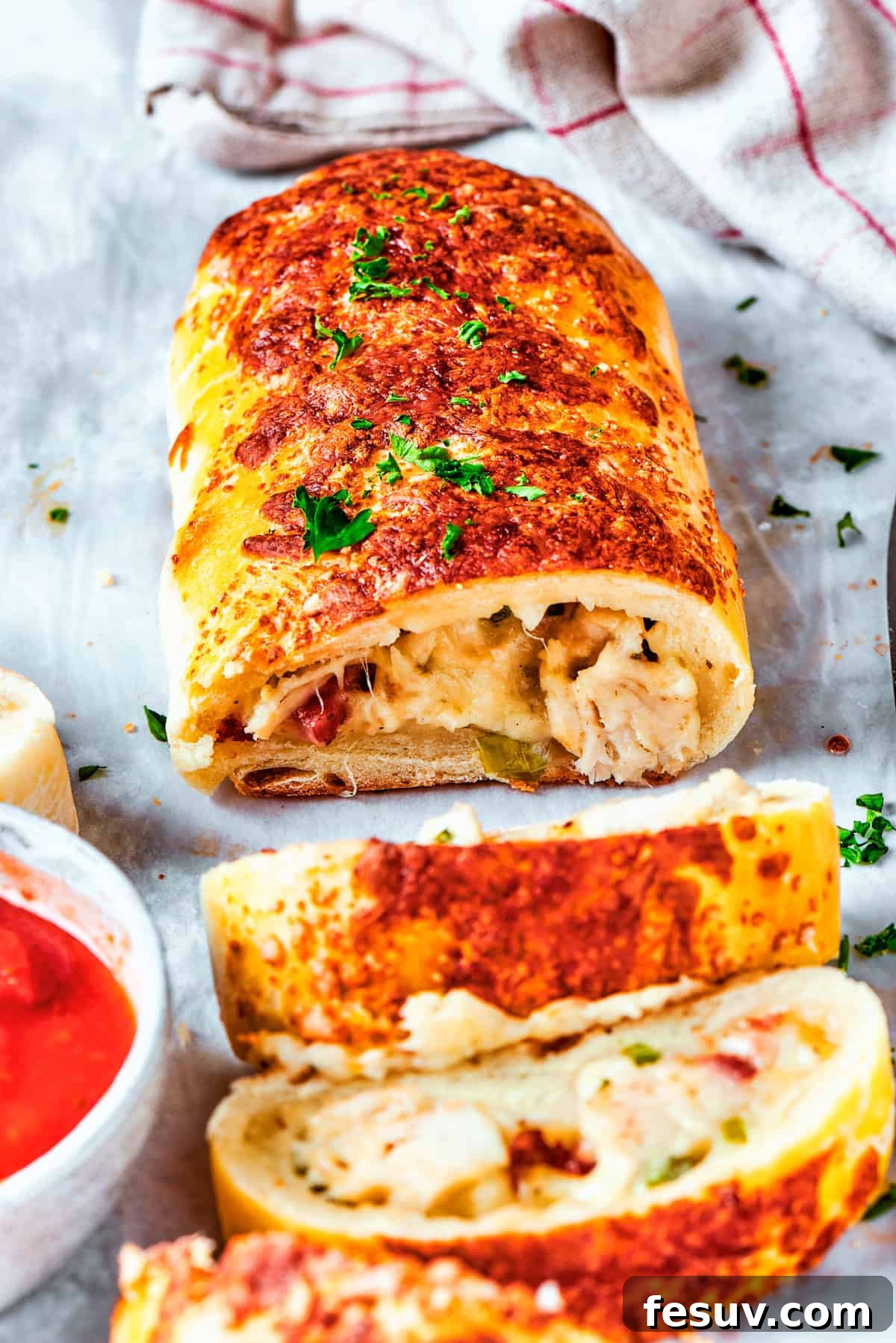 A freshly baked and sliced chicken bake sandwich, revealing its warm, cheesy interior.