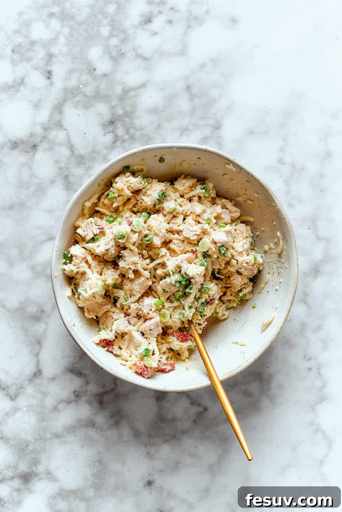 A bowl filled with thoroughly mixed Costco chicken bake filling.
