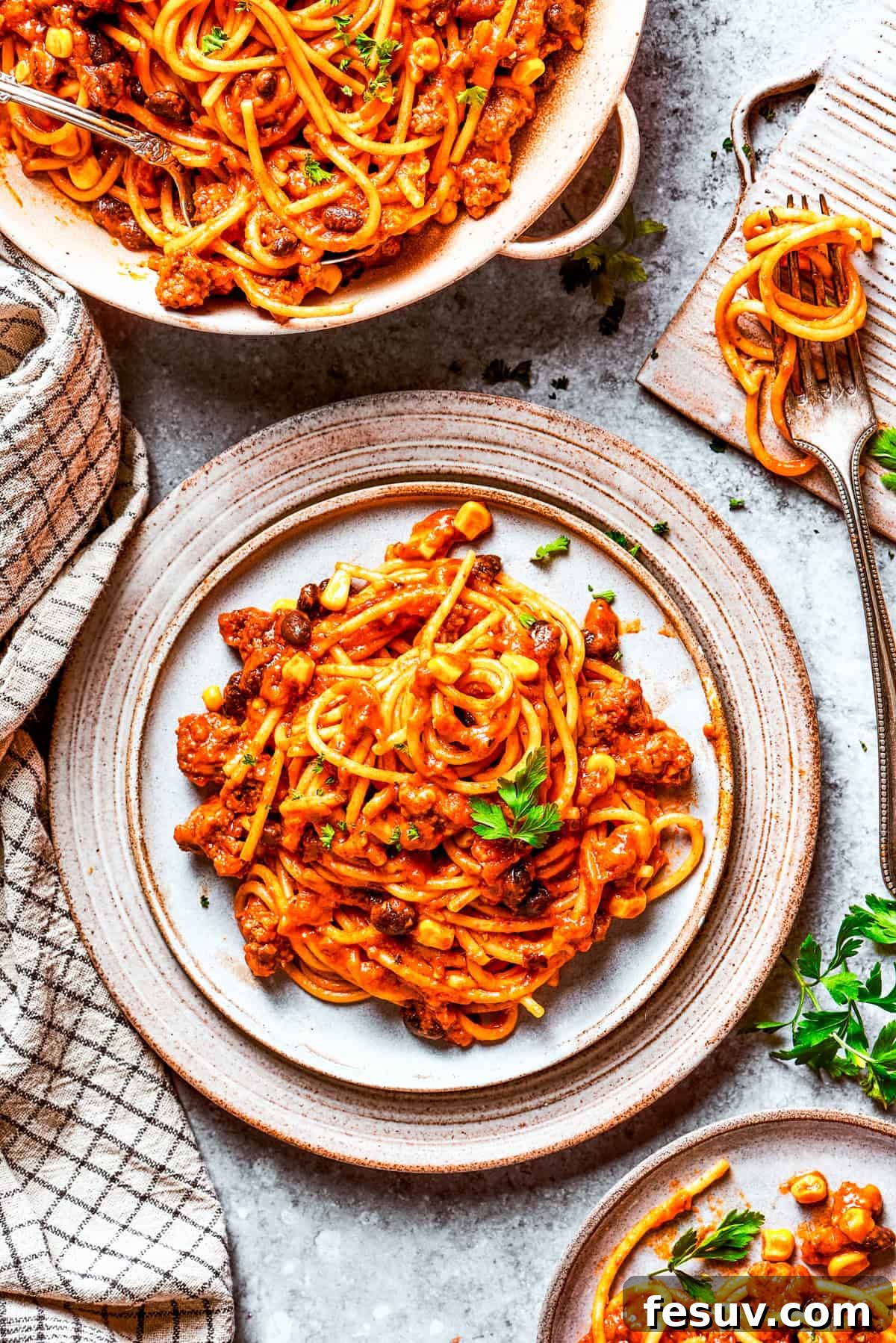 Served Mexican spaghetti, beautifully plated and garnished for a hearty dinner. Two plates of Mexican spaghetti served on a dinner table, garnished and ready to eat.