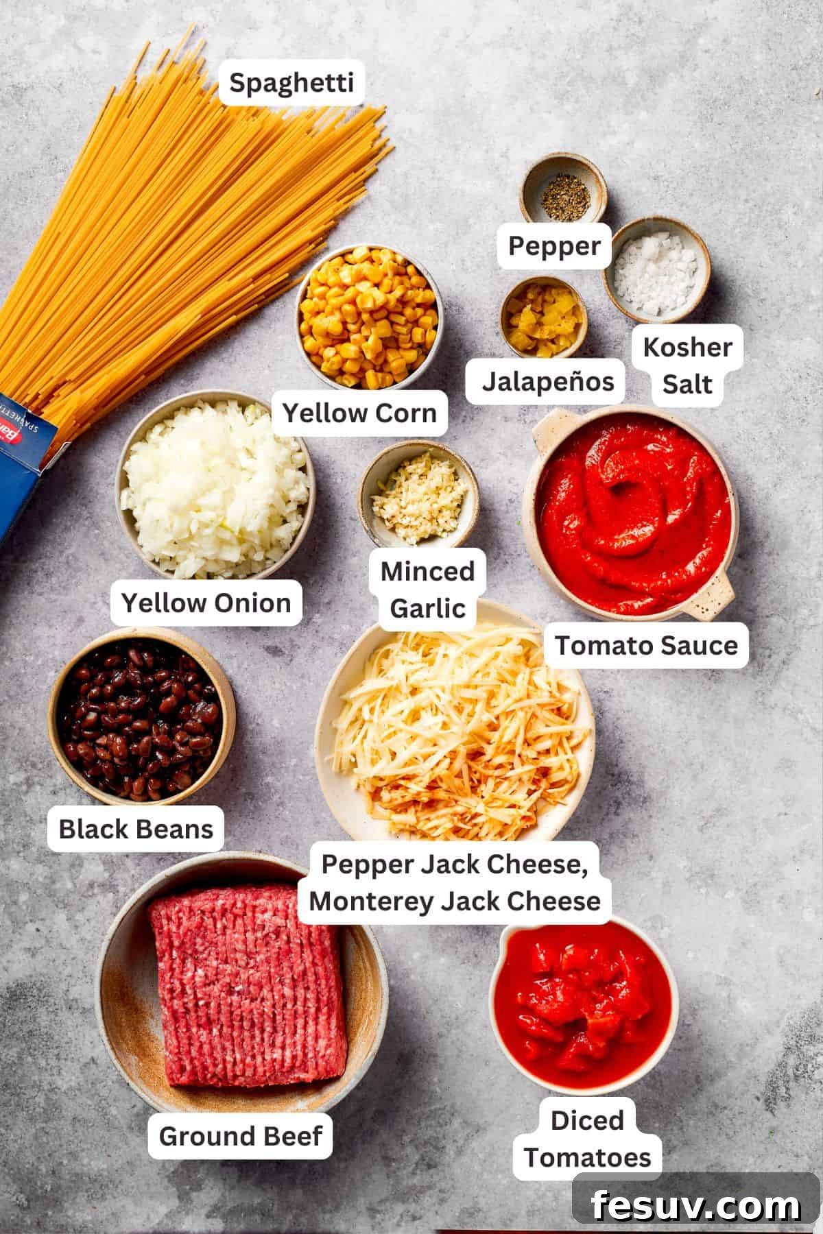 A visual guide to all the key ingredients needed for making hearty Mexican taco spaghetti. All the core ingredients for Mexican taco spaghetti are neatly arranged and text-labeled.