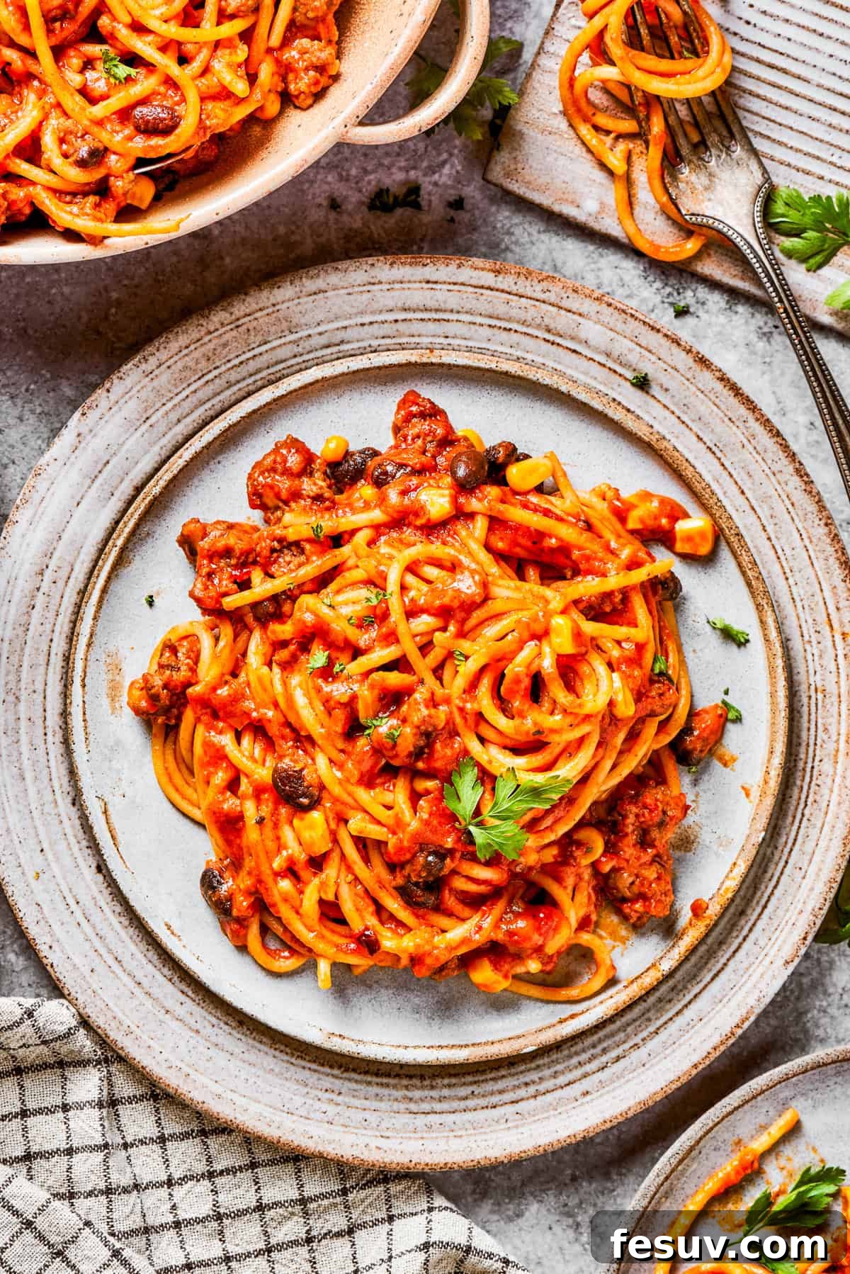 A vibrant and appetizing plate of Mexican taco spaghetti, ready to be enjoyed. A serving of Mexican spaghetti artfully arranged on a plate.