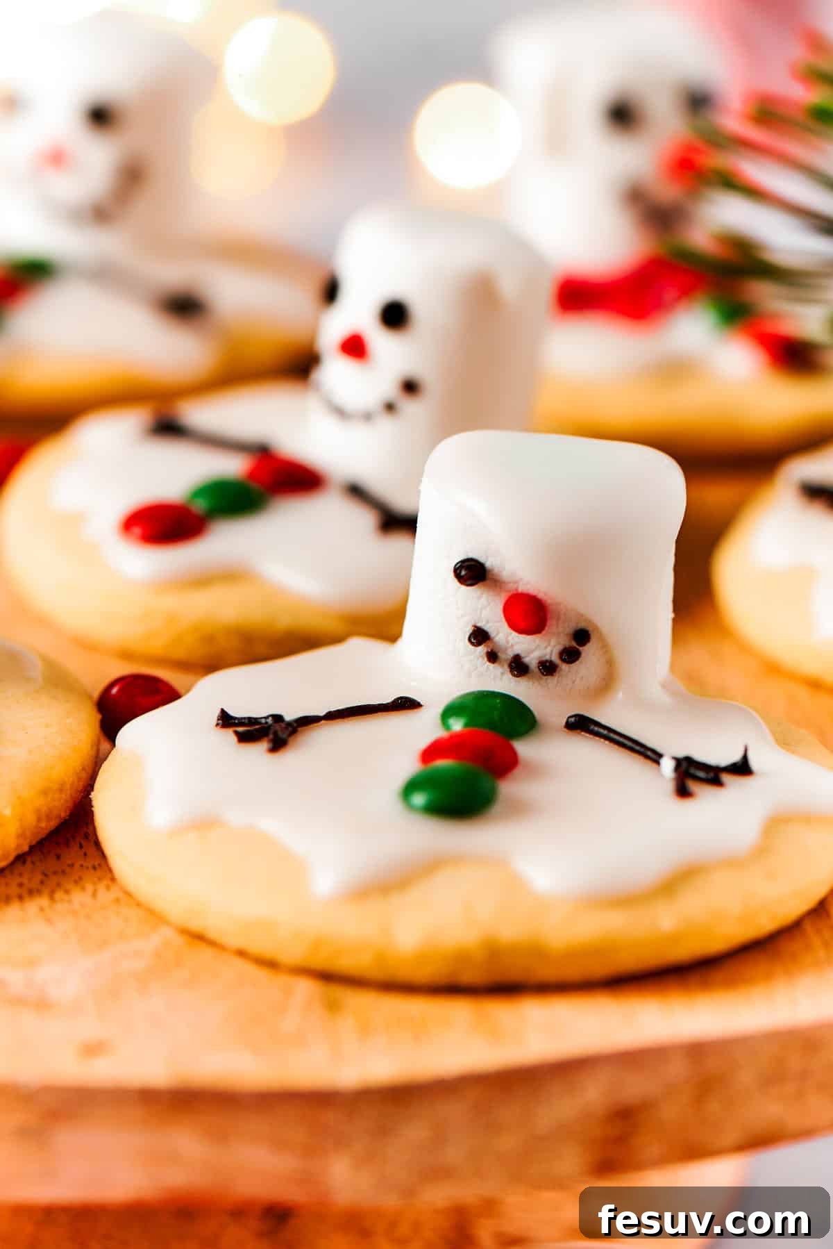 The cutest Melted Snowman Cookies top buttery homemade sugar cookies with a thick vanilla frosting and a fluffy marshmallow! Close-up view of a beautifully decorated melted snowman cookie, ready to be enjoyed.