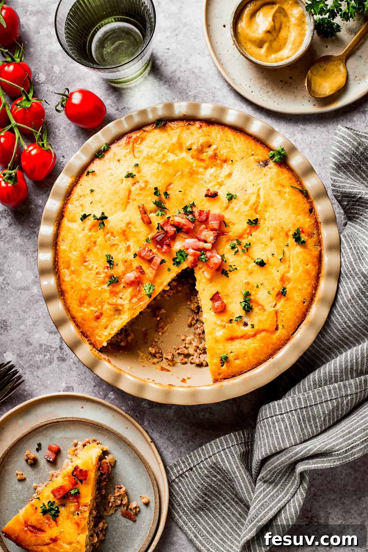 Overhead image of a beautifully baked cheeseburger pie in a classic pie dish, with a perfect wedge already cut out, ready to be served.