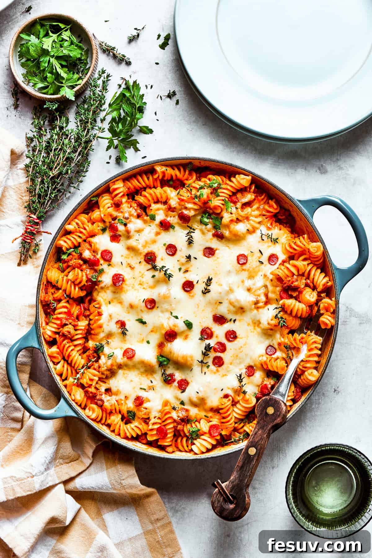 A wide shot of a baking dish filled with homemade pizza pasta, generously covered with melted mozzarella cheese and pepperoni, ready to be served.