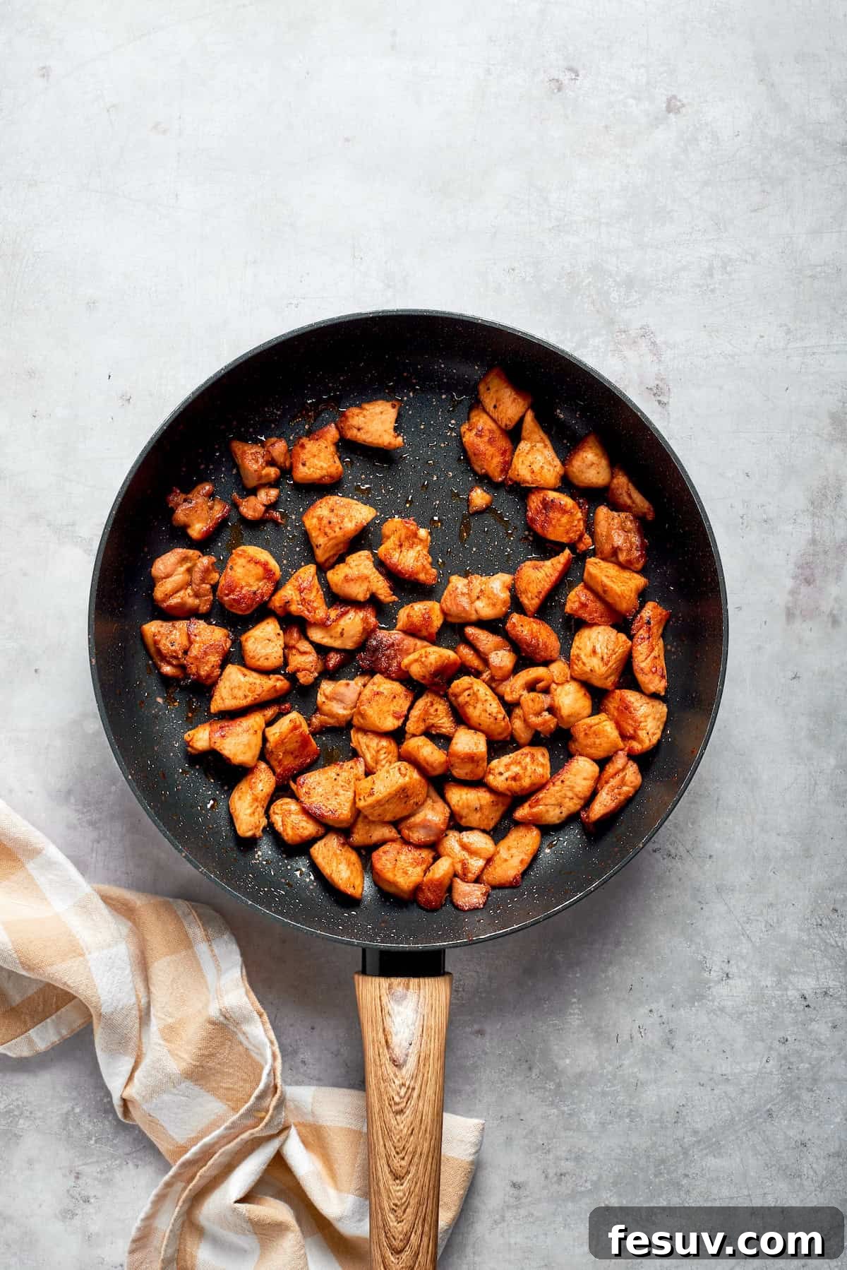 Golden-brown chicken pieces beautifully seared in a hot skillet, indicating they are perfectly cooked.
