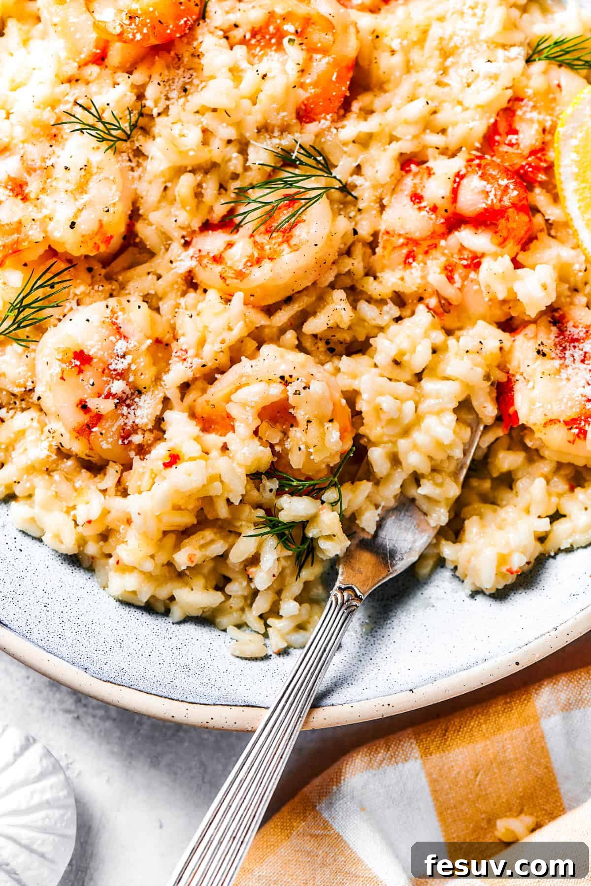 Creamy shrimp risotto served on a dinner plate, garnished with fresh herbs.