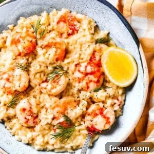 Shrimp risotto served on a plate with a wedge of lemon to the side.
