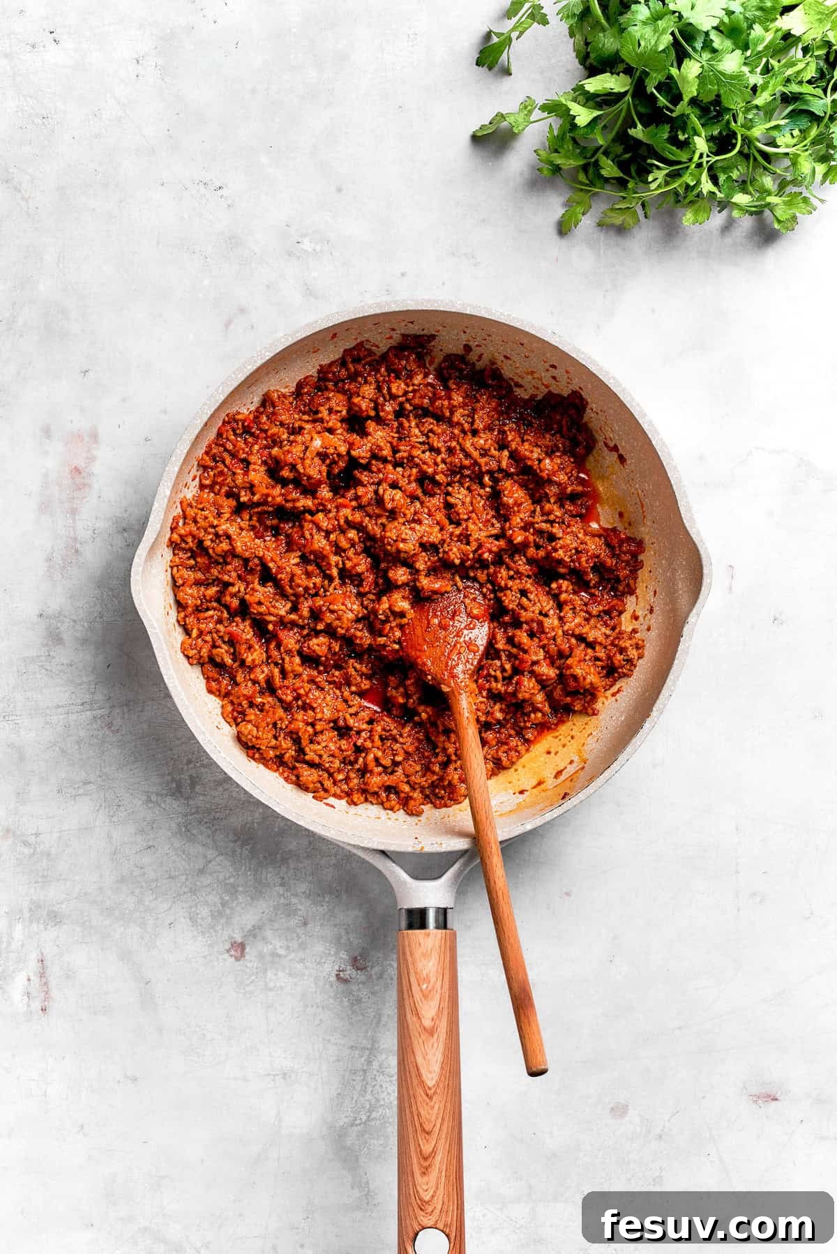 The savory ground beef filling for Dorito casserole, seasoned with taco spices and salsa, simmering in a skillet, ready for the creamy additions.