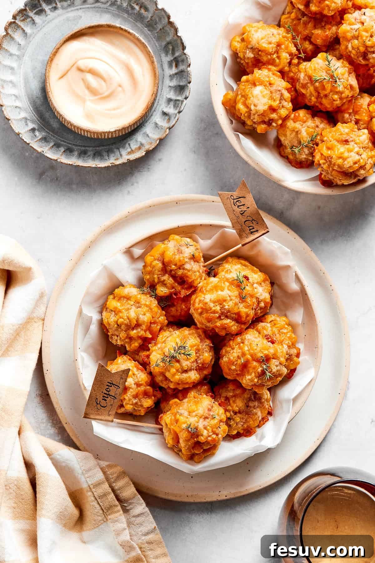 This sausage balls recipe relies on Bisquick, pork sausage, and Italian seasoning for an easy appetizer. Don't forget the dipping sauce! Bowls of sausage balls and dip.