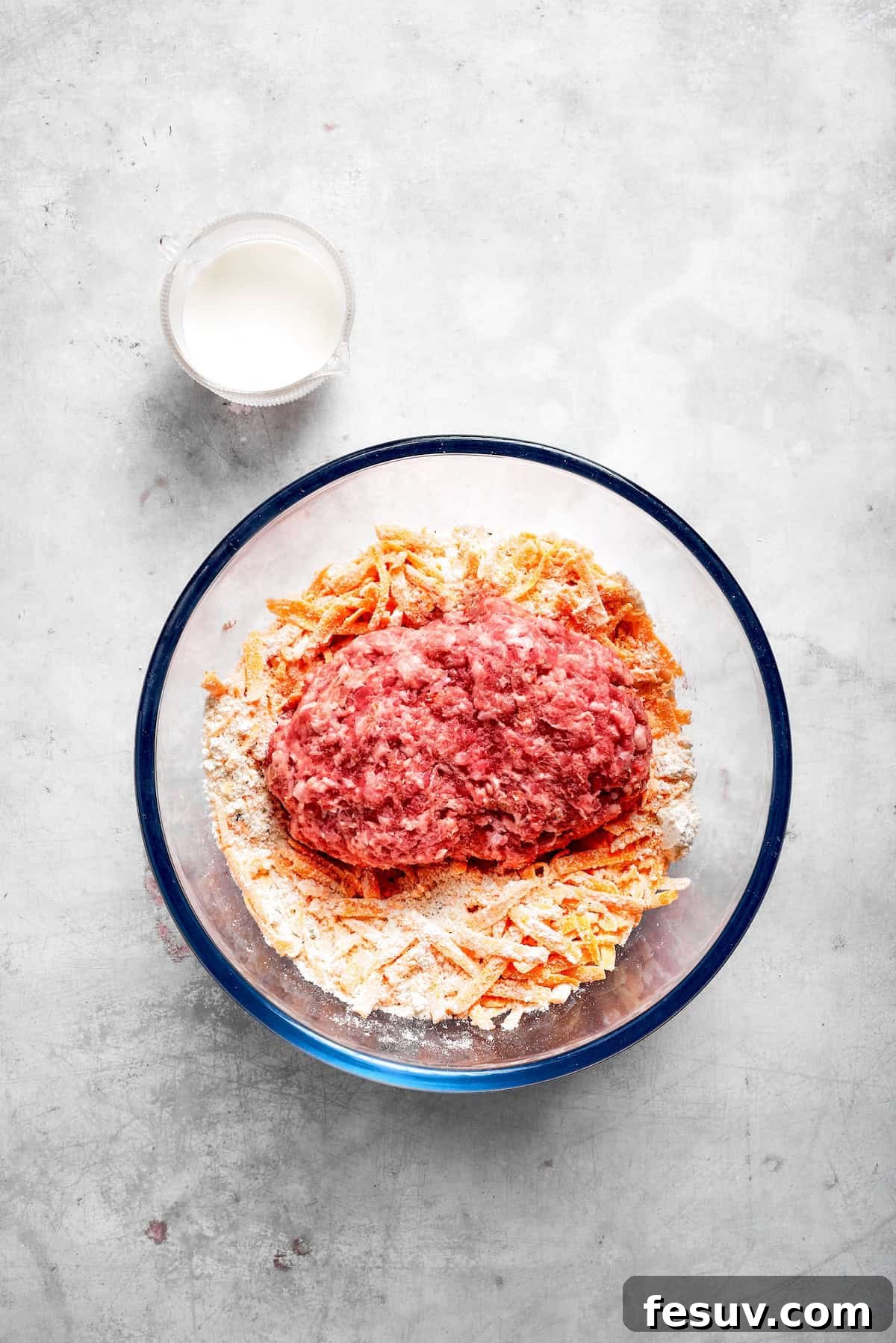 This sausage balls recipe relies on Bisquick, pork sausage, and Italian seasoning for an easy appetizer. Don't forget the dipping sauce! The ingredients for sausage balls placed in a glass bowl.