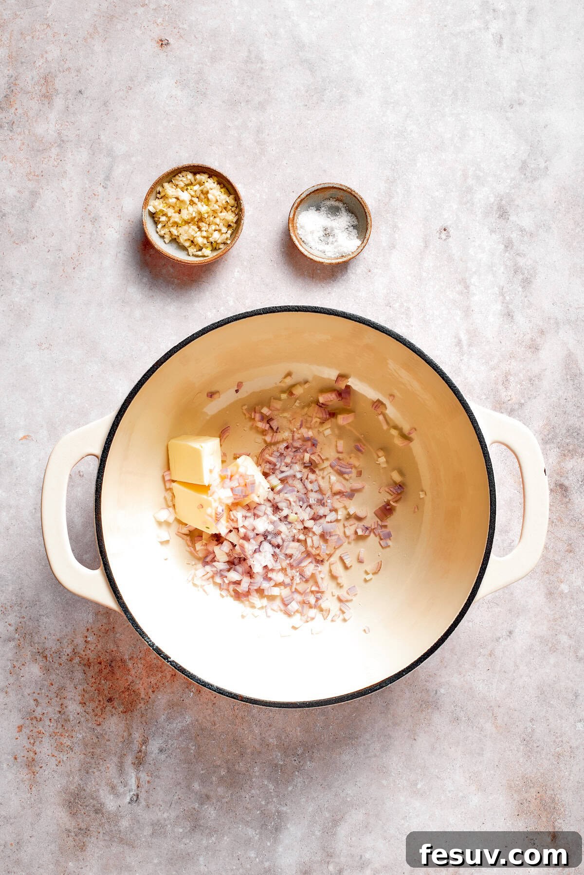 Butter melting in a large pot with chopped shallots beginning to soften and become translucent.