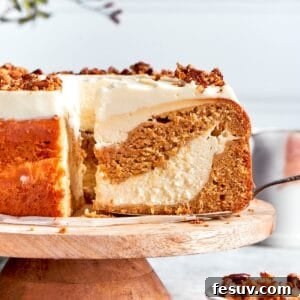 A slice is removed from a platter of carrot cake cheesecake.