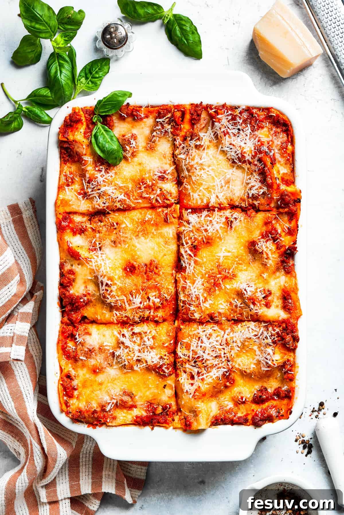 A pan of beef lasagna cut into squares, showcasing layers of pasta, meat sauce, and melted cheese.