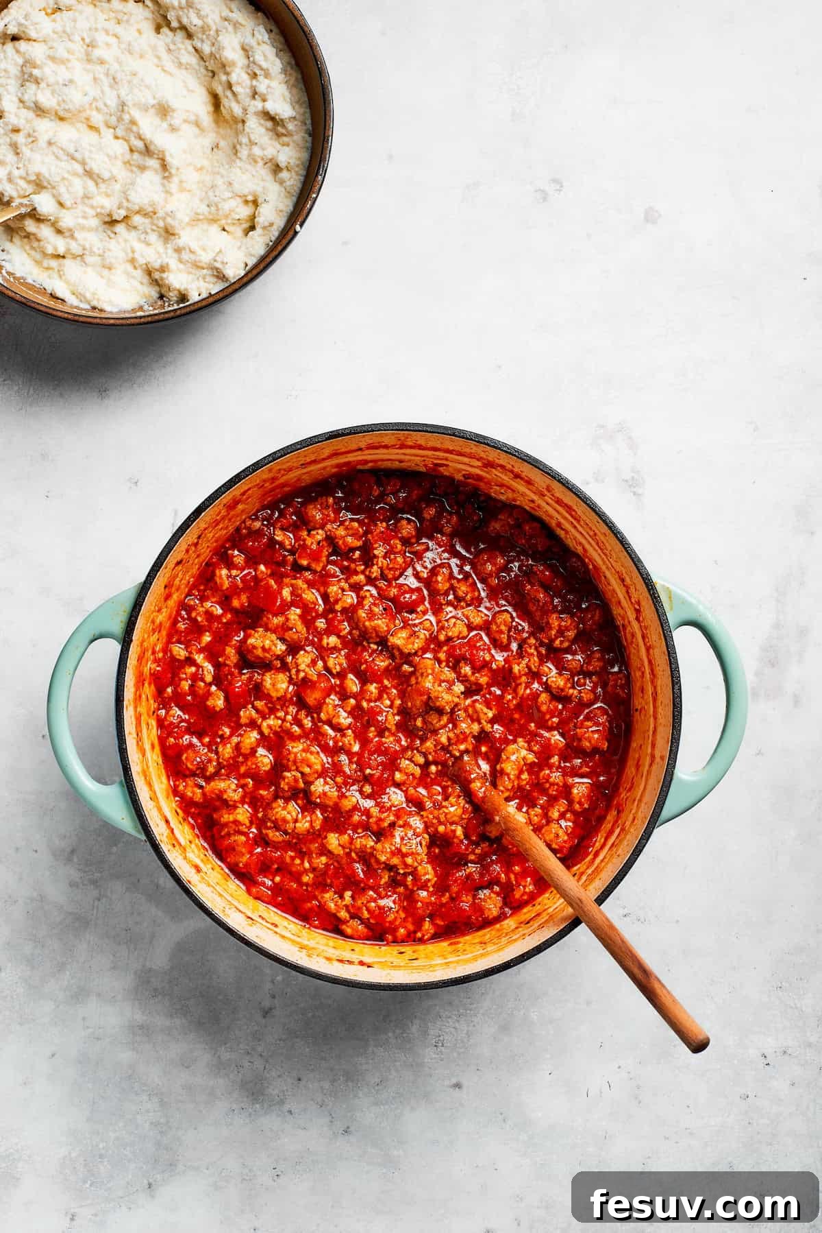 Beef tomato sauce simmers gently in a large pot, developing rich flavors.
