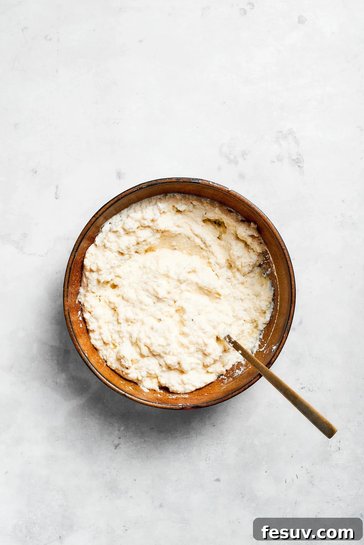Ricotta cheese mix for lasagna in a bowl, perfectly blended and ready to use.