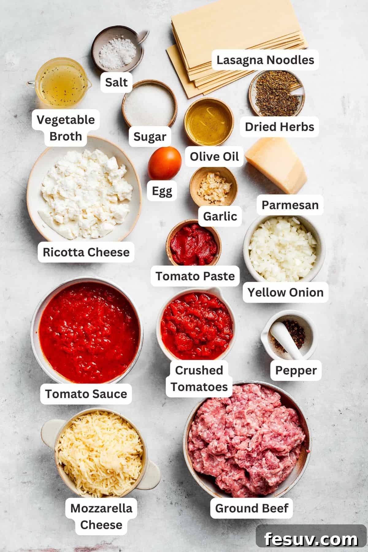 Ingredients for beef lasagna are text-labeled and laid out on a wooden board.